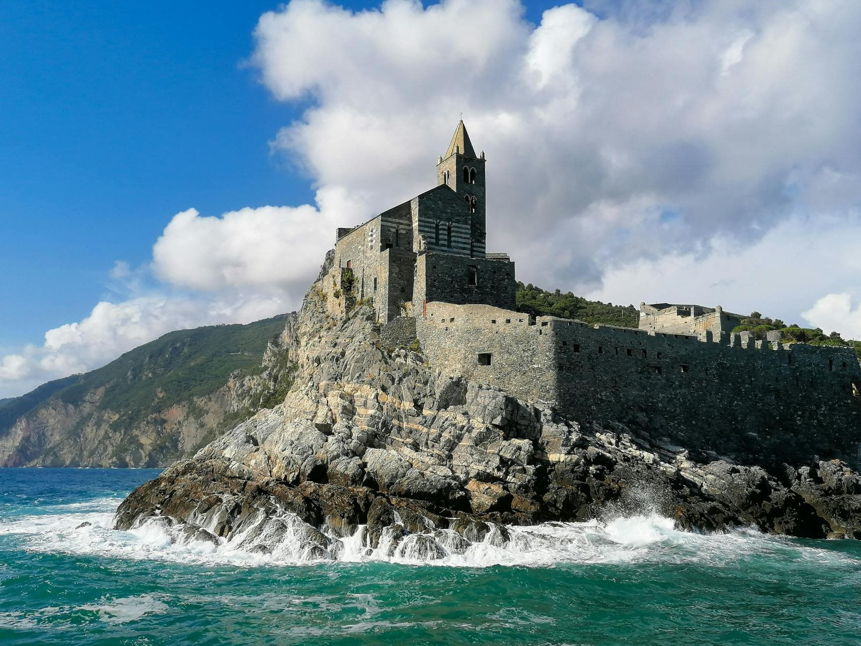 Stunning view of San Pietro Church in Porto Venere, Italy, on rugged coastal rocks.