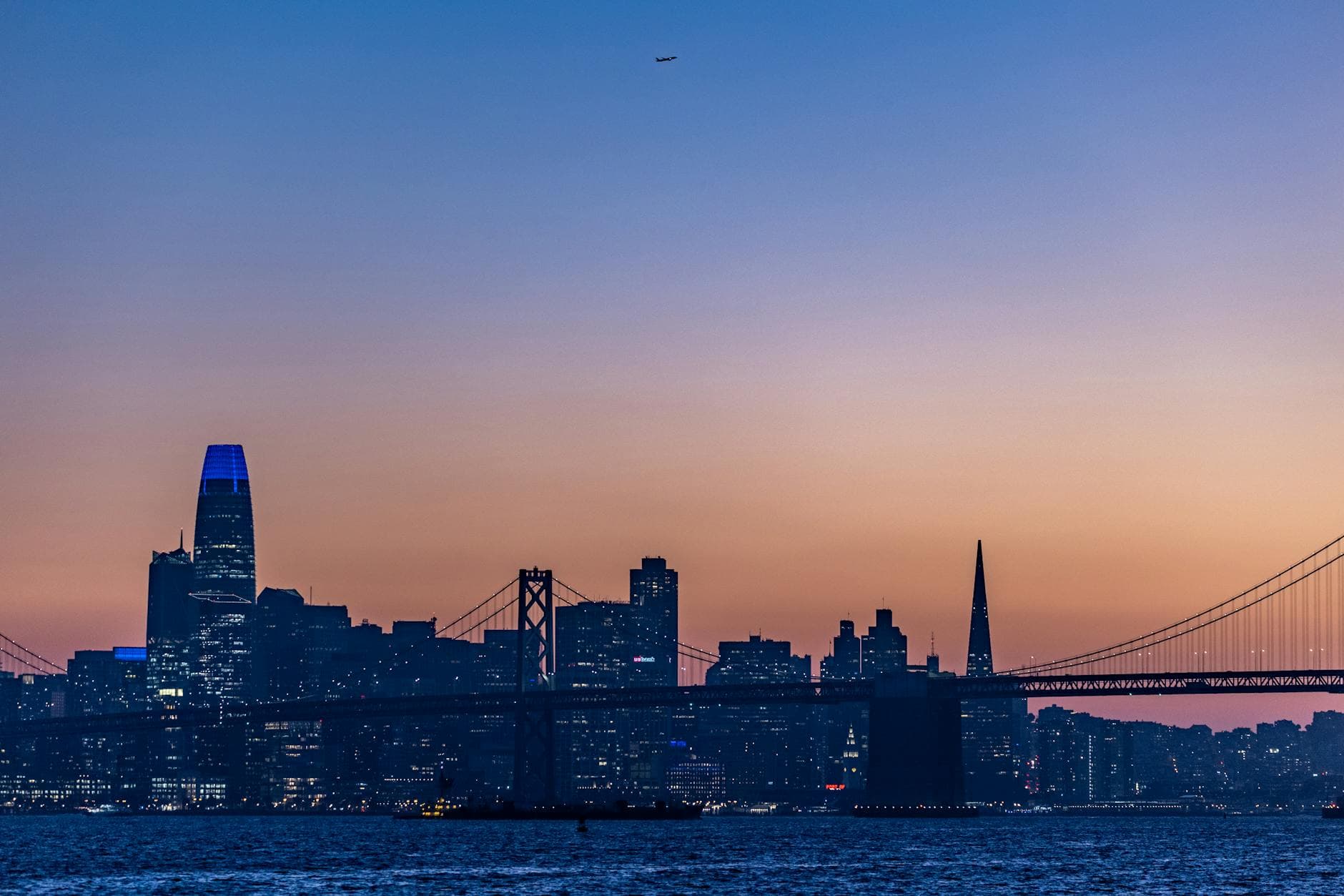 Beautiful sunset view of San Francisco skyline featuring the Bay Bridge and iconic buildings.