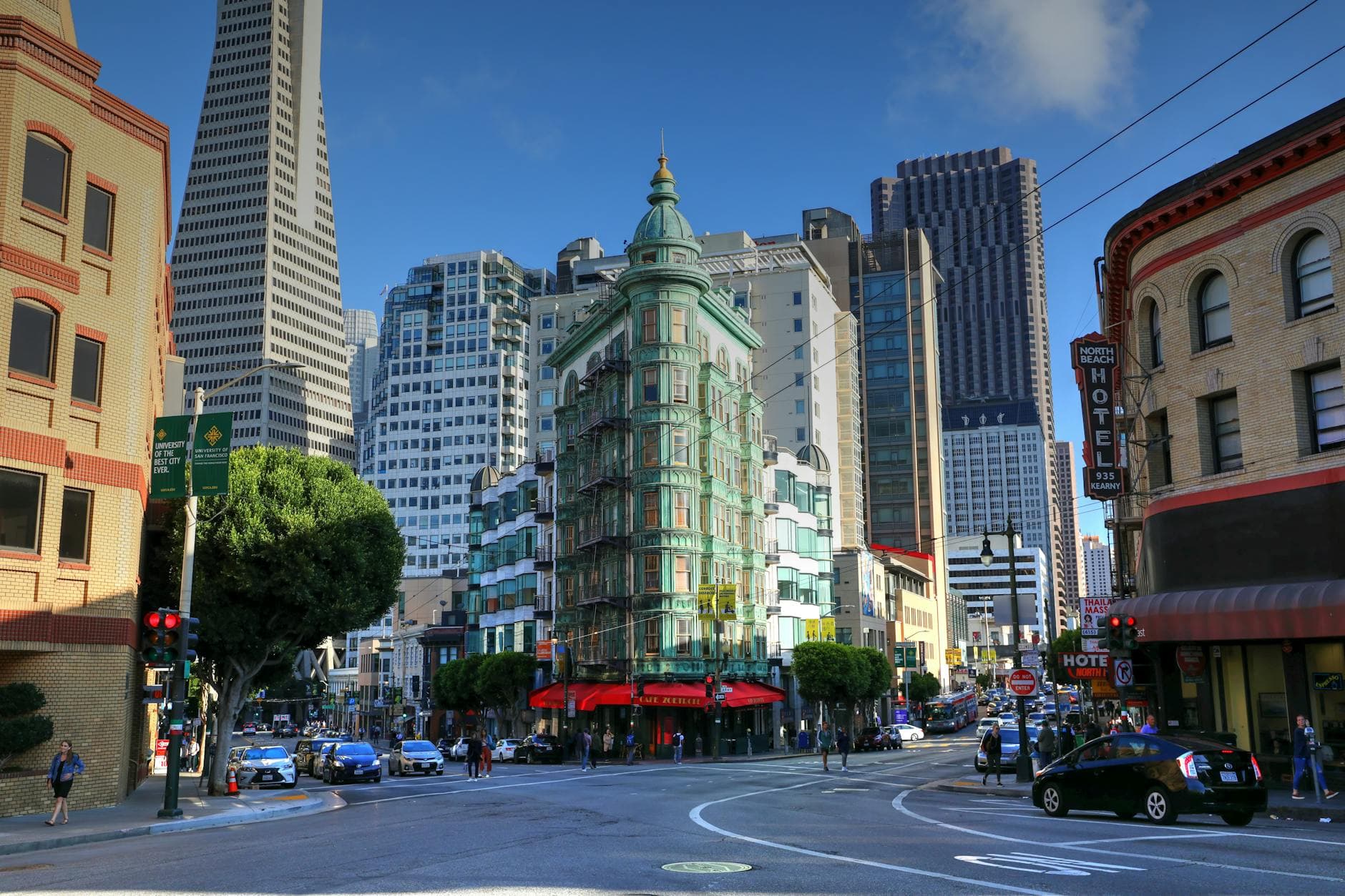 View of San Francisco's Columbus Tower with the Transamerica Pyramid in the background on a sunny day.
