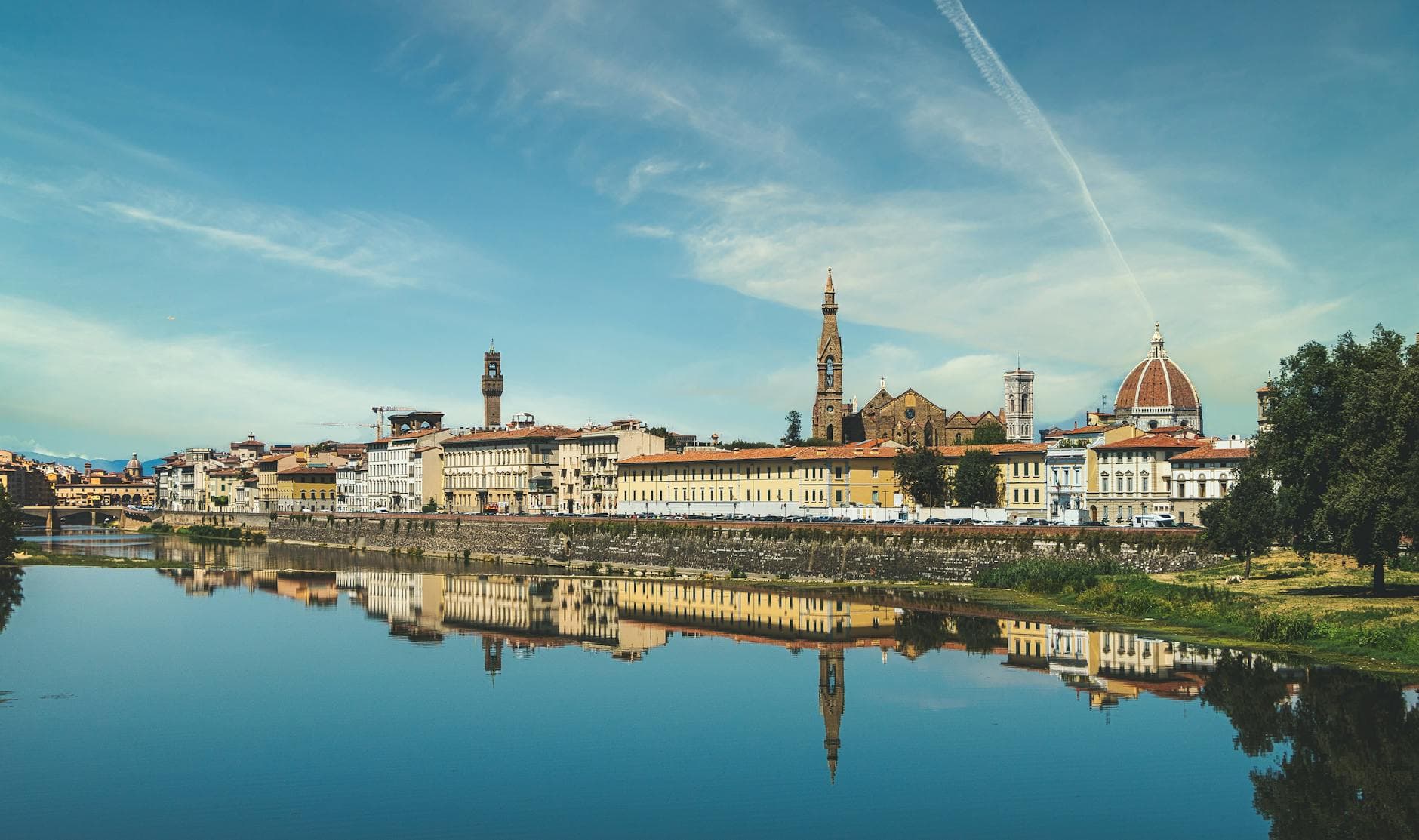 Scenic view of Florence's historic skyline and Arno River reflection in Tuscany, Italy.