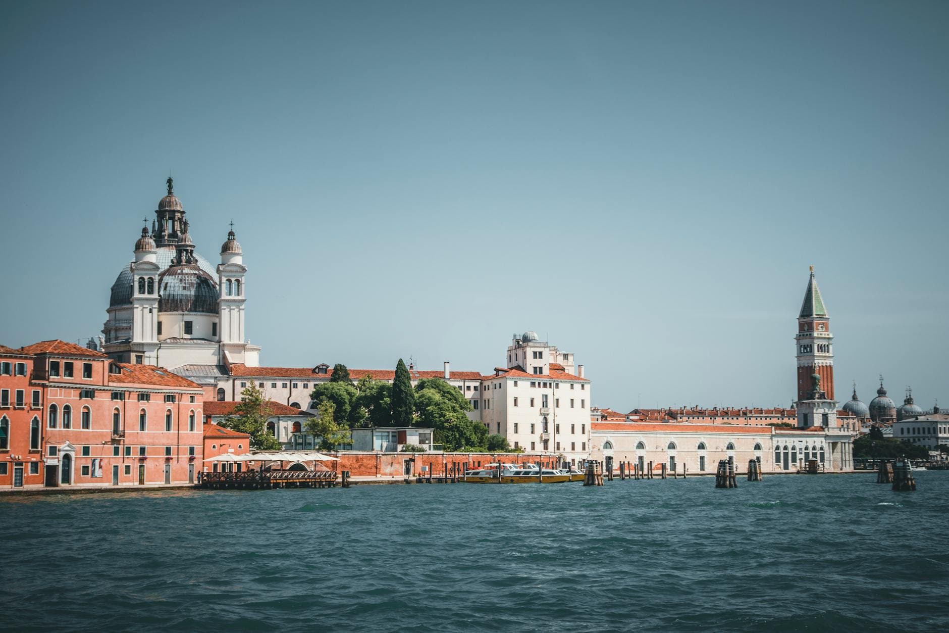 Scenic view of Venice's historic architecture including a basilica and bell tower by the water.