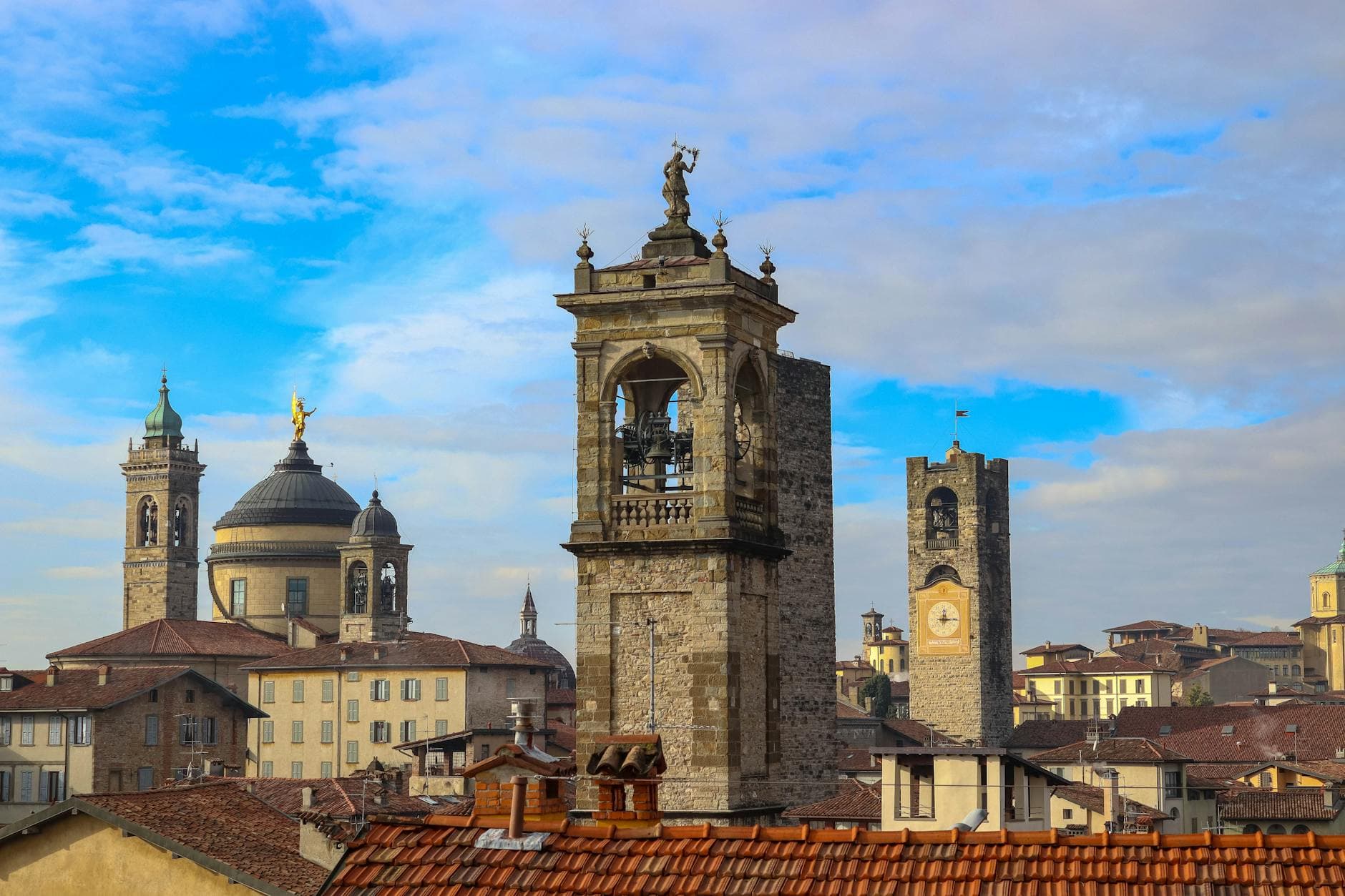 Scenic view of historic towers in Bergamo, Italy, under a vibrant blue sky.