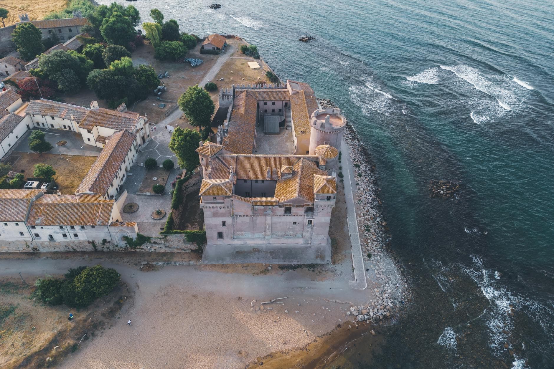 Drone shot of historic Santa Severa Castle on the Italian seashore with a view of the surrounding area.