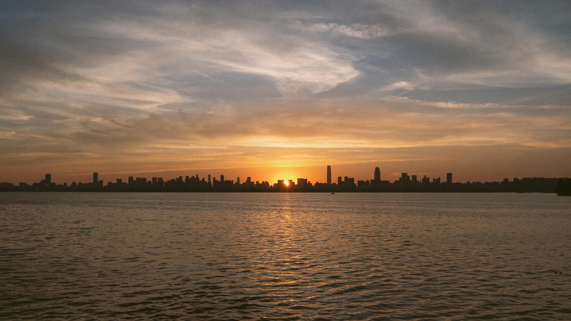 Silhouette of Wuhan city skyline with a stunning sunset over the water.