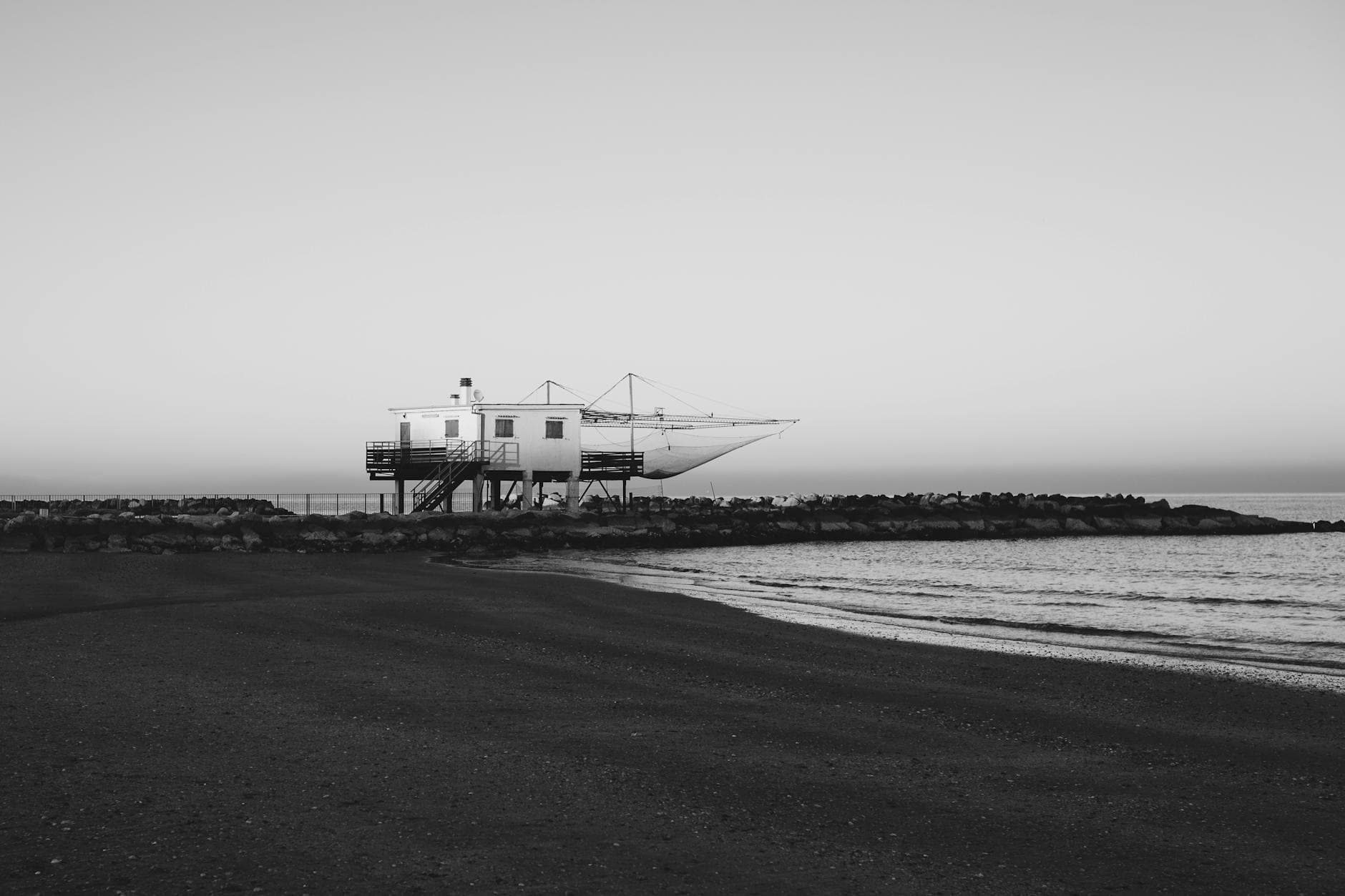 View of a coastal structure at Lido di Savio beach in Italy, captured in black and white.