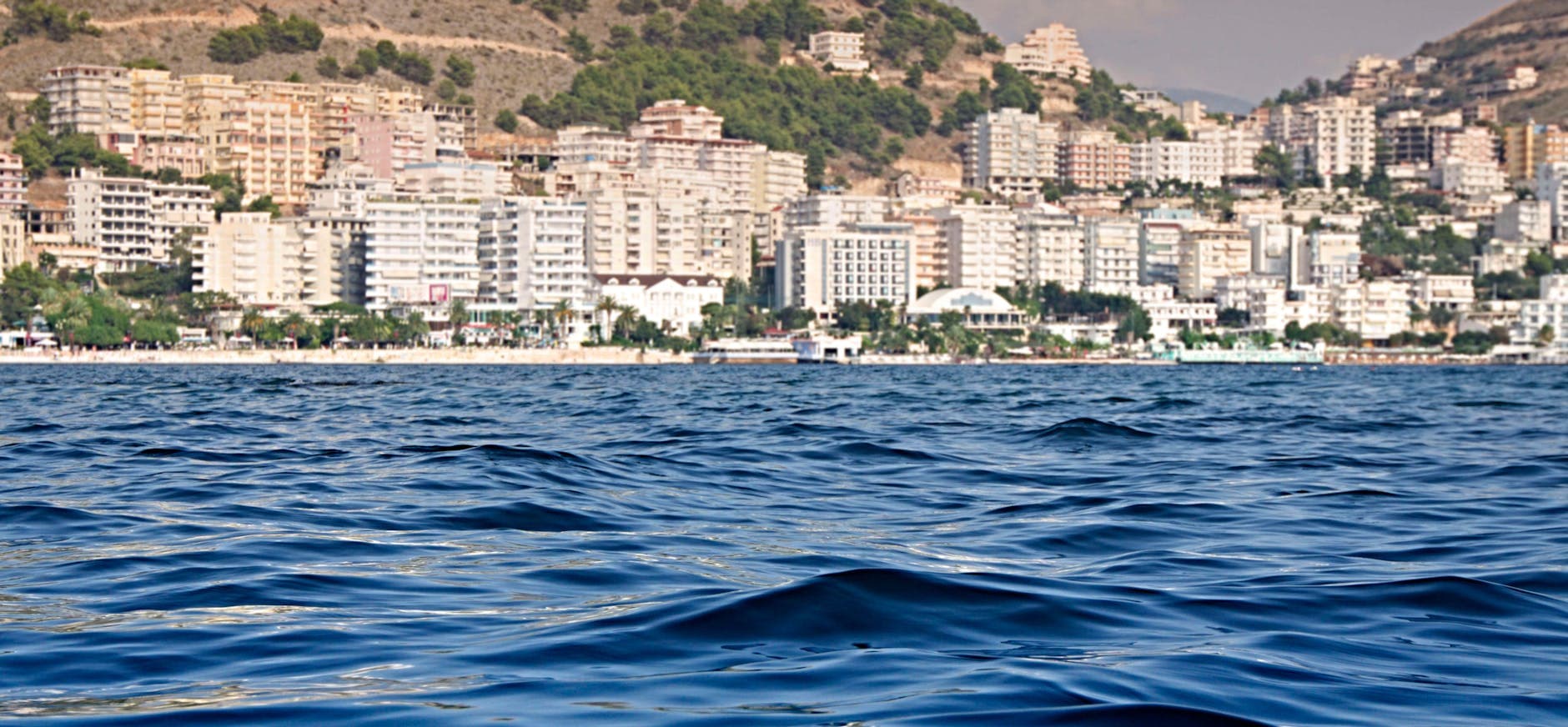 Beautiful view of the Sarandë waterfront with buildings along the seashore.