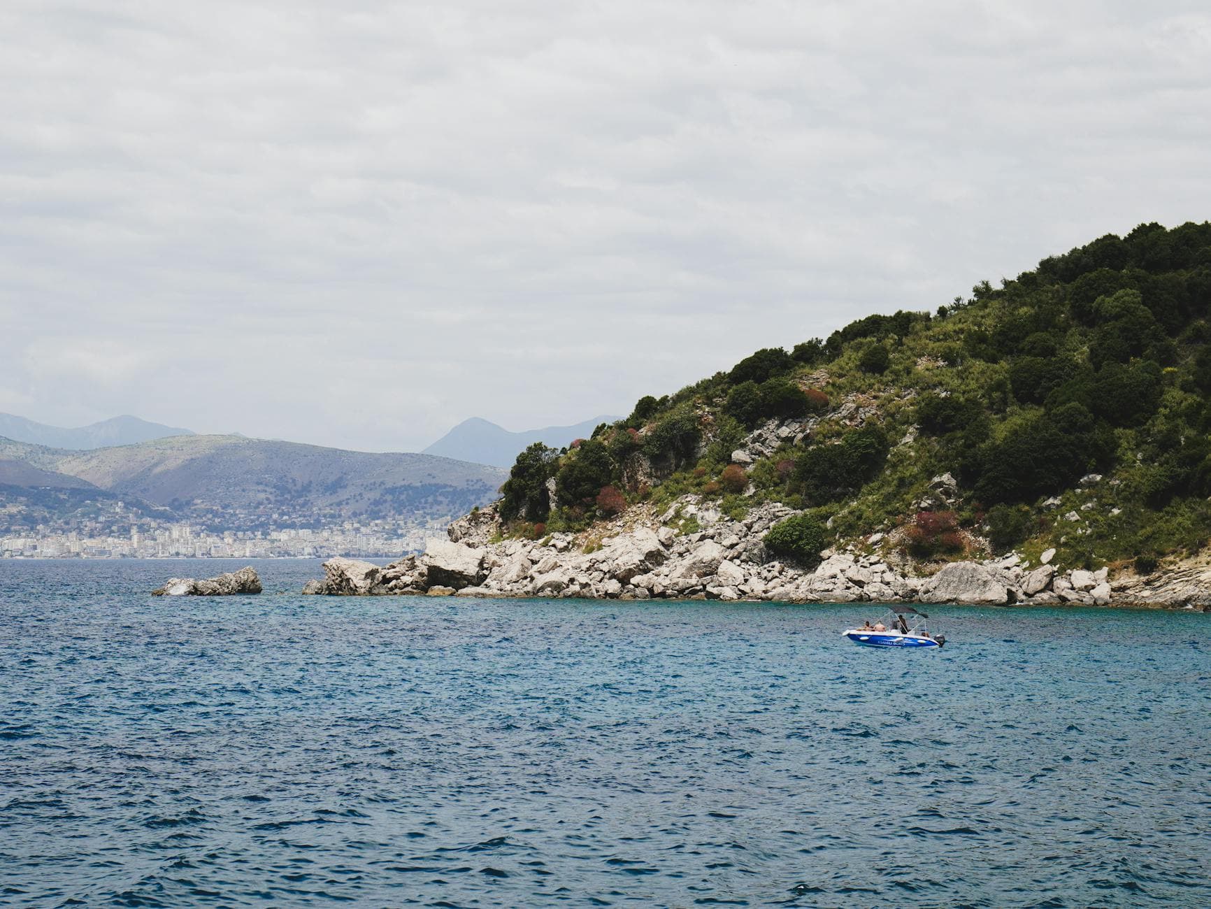 Explore the stunning coastline of Sarandë, Albania with clear blue waters and lush greenery.