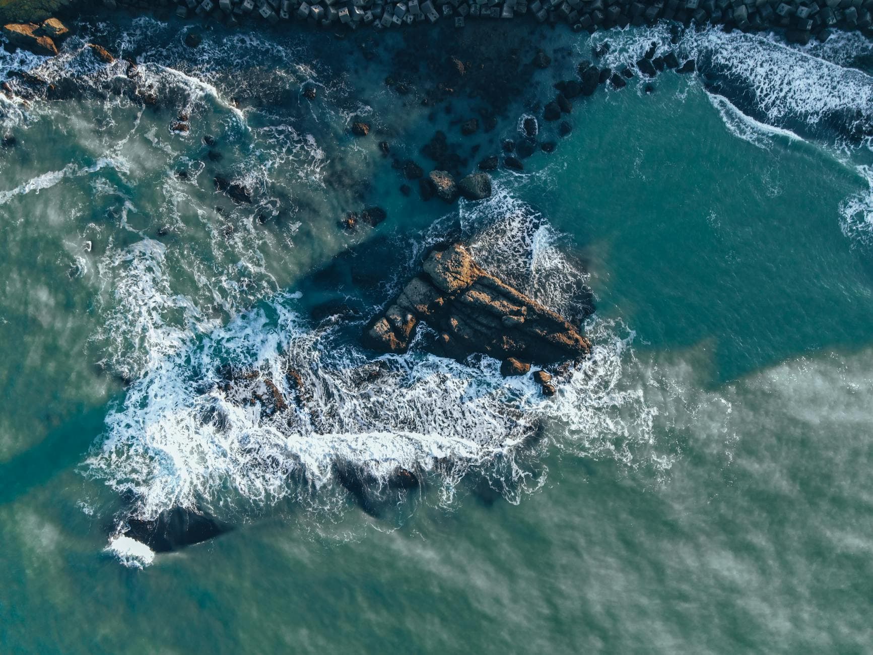 Dramatic aerial view of waves crashing against the rocky coastline in Sarıyer, Turkey.