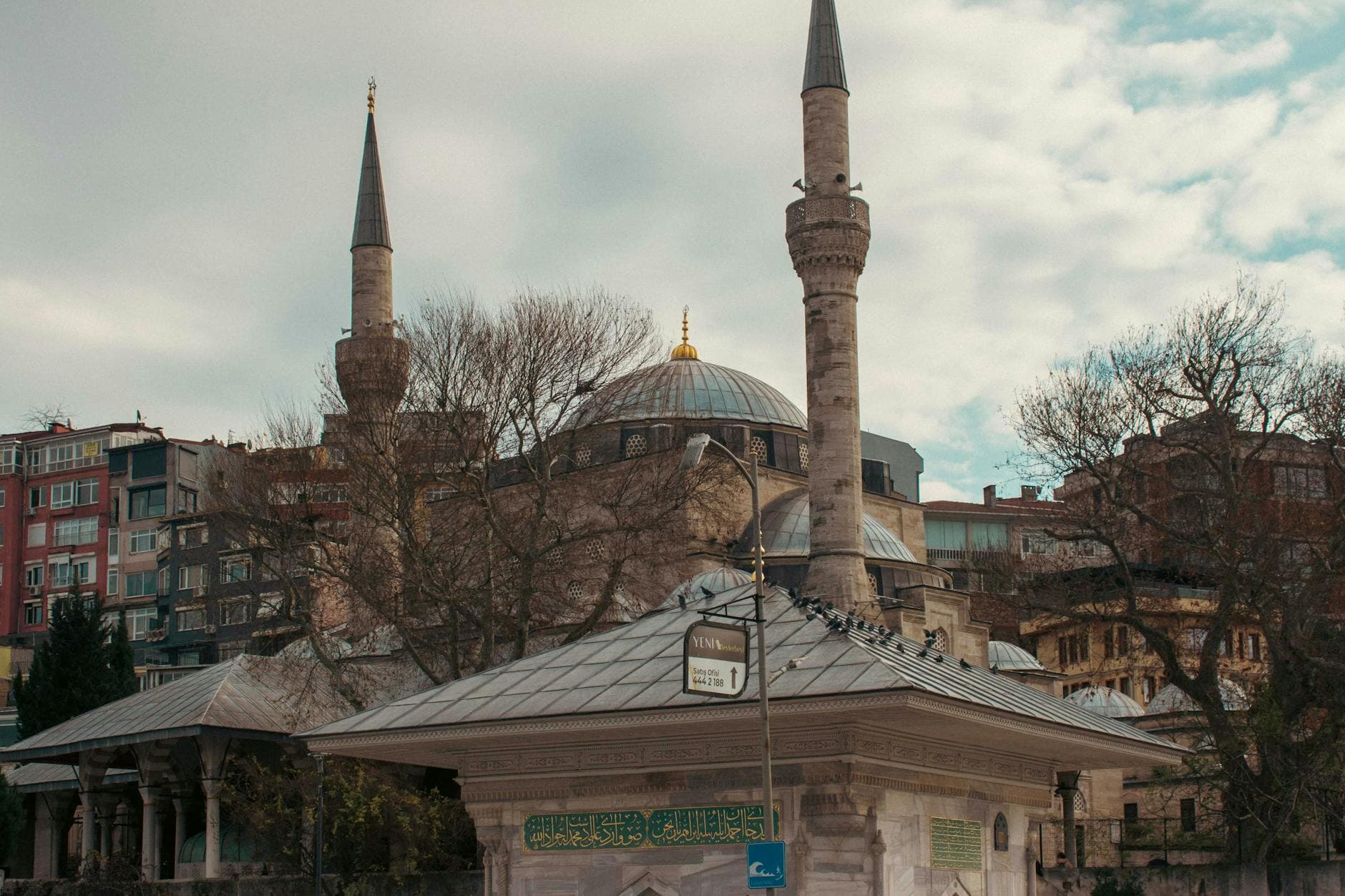 A scenic view of a historic mosque with minarets in Istanbul, showcasing urban architecture and vibrant city life.