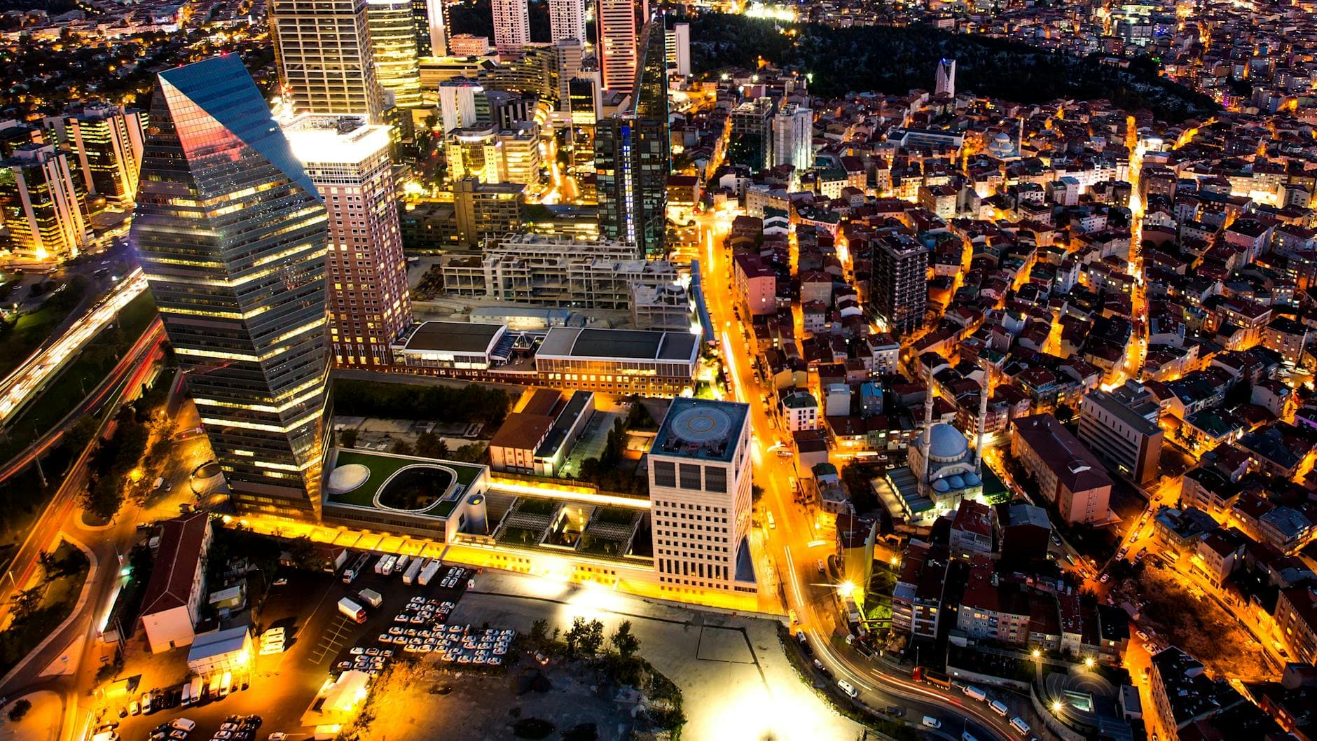 Breathtaking aerial view of Istanbul's vibrant skyline at dusk, with illuminated skyscrapers and bustling streets.