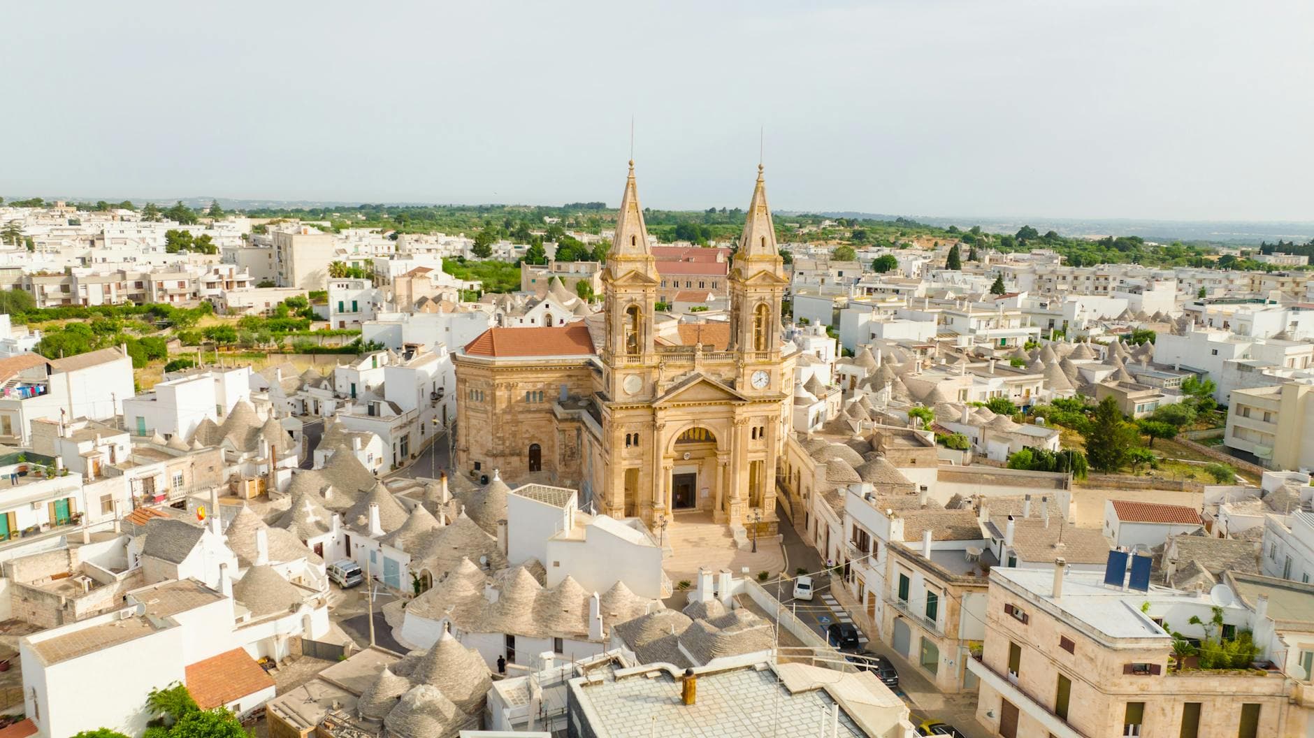 Stunning aerial shot of a historic church in the picturesque town of Alberobello, Italy.