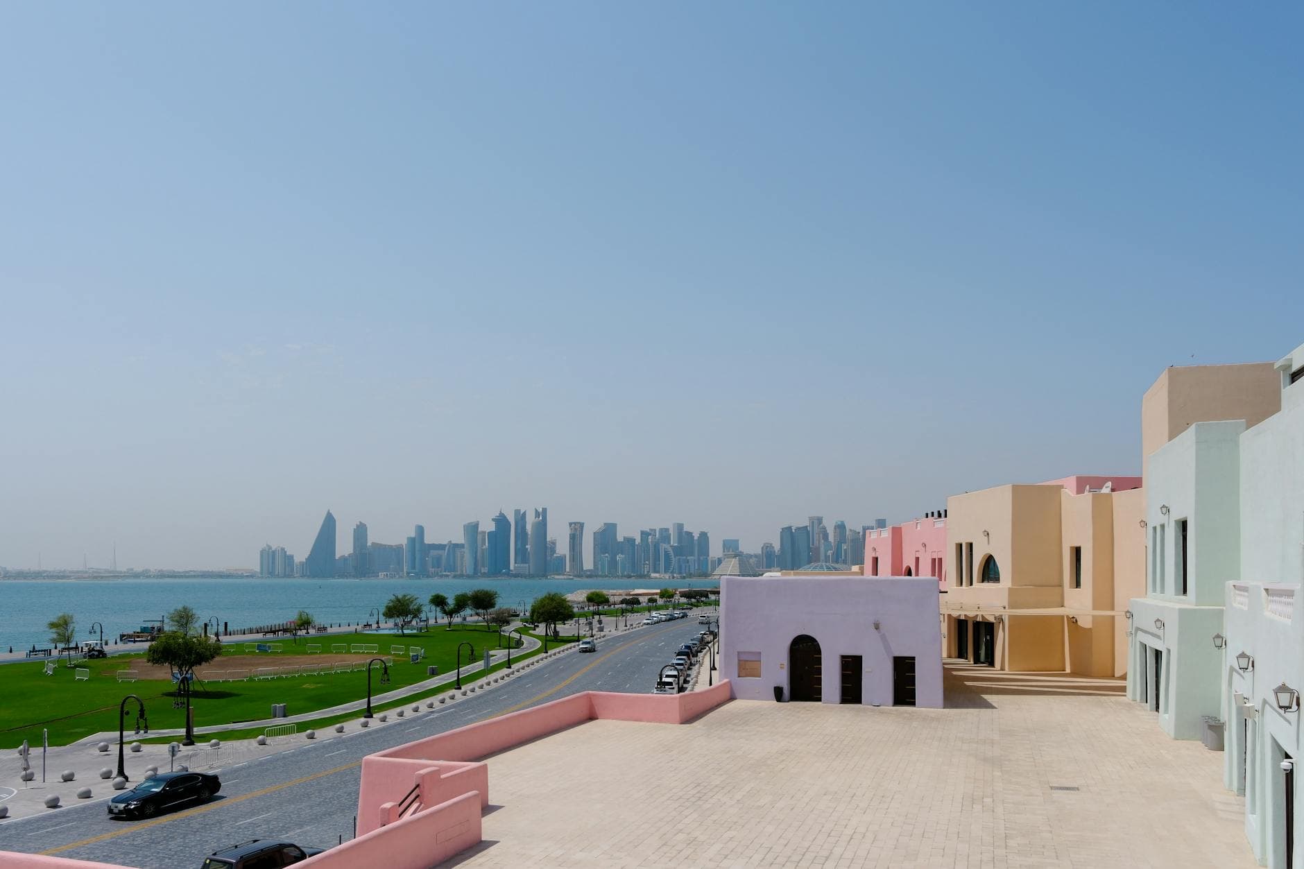 Scenic view of Doha skyline with pastel-colored buildings along the waterfront.