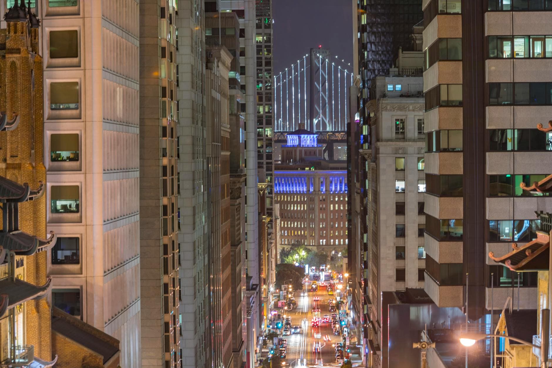 Stunning nighttime view of San Francisco with Bay Bridge in the background.