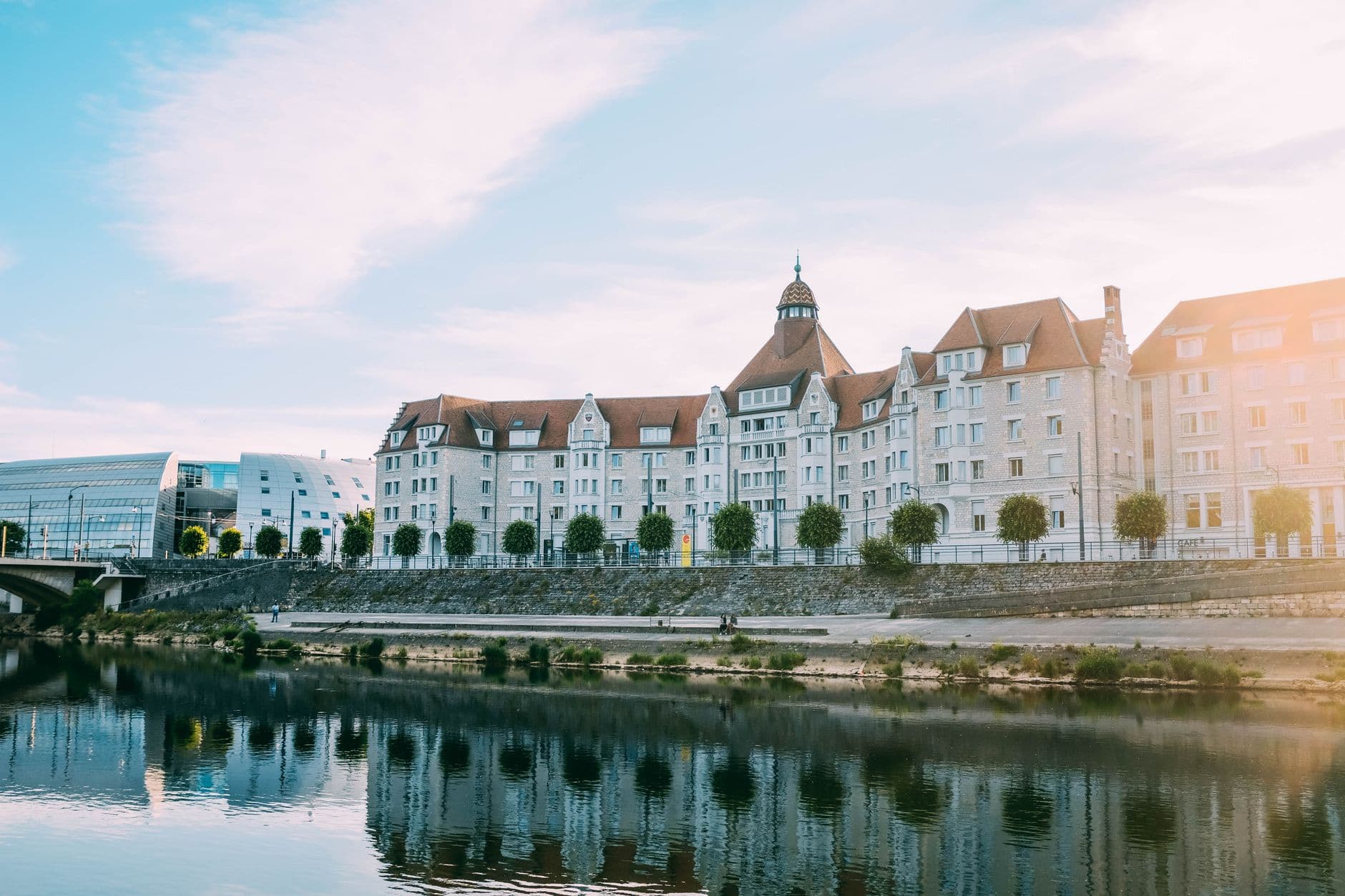 Scenic view of historic buildings reflecting on a tranquil river.