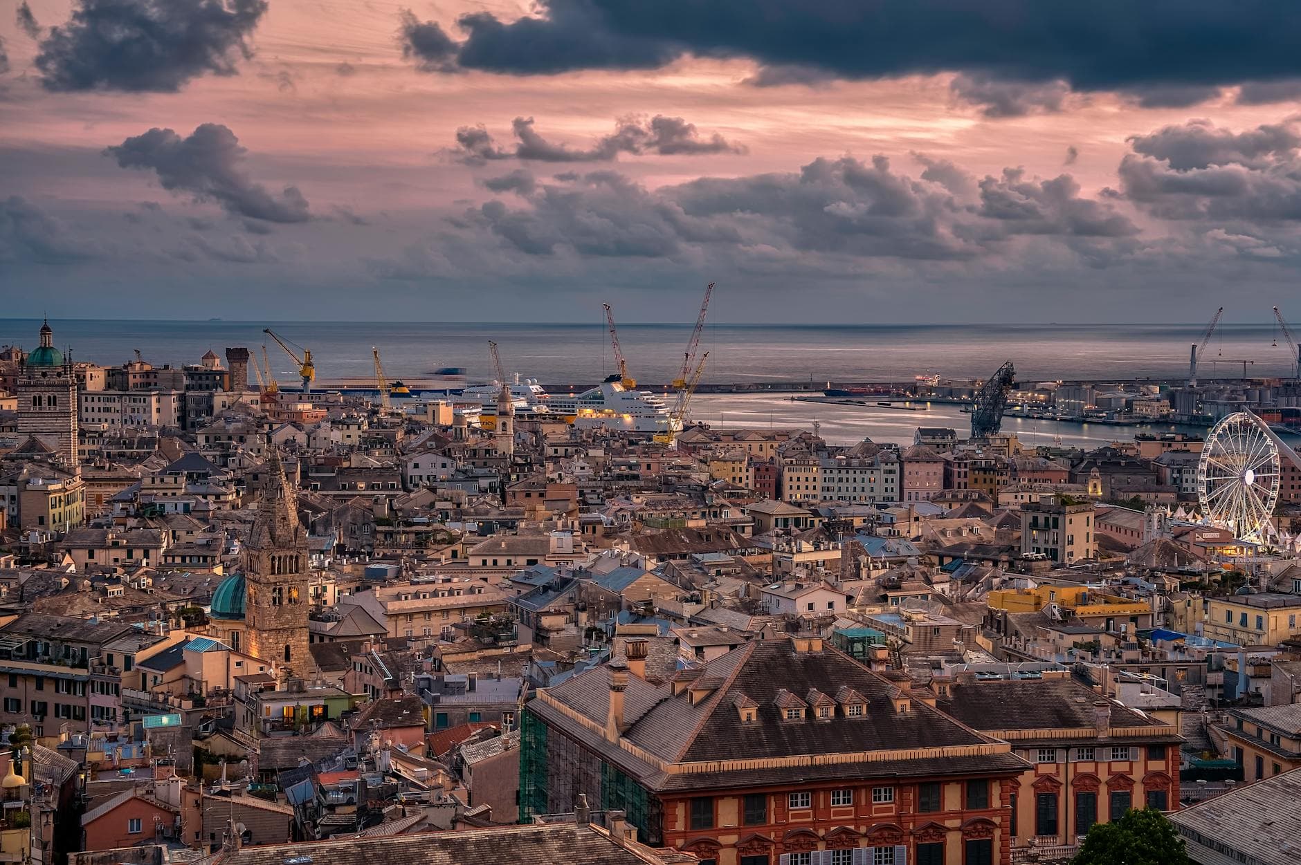 Stunning aerial view of Genoa, Italy at sunset showcasing the city's architecture and coastline.