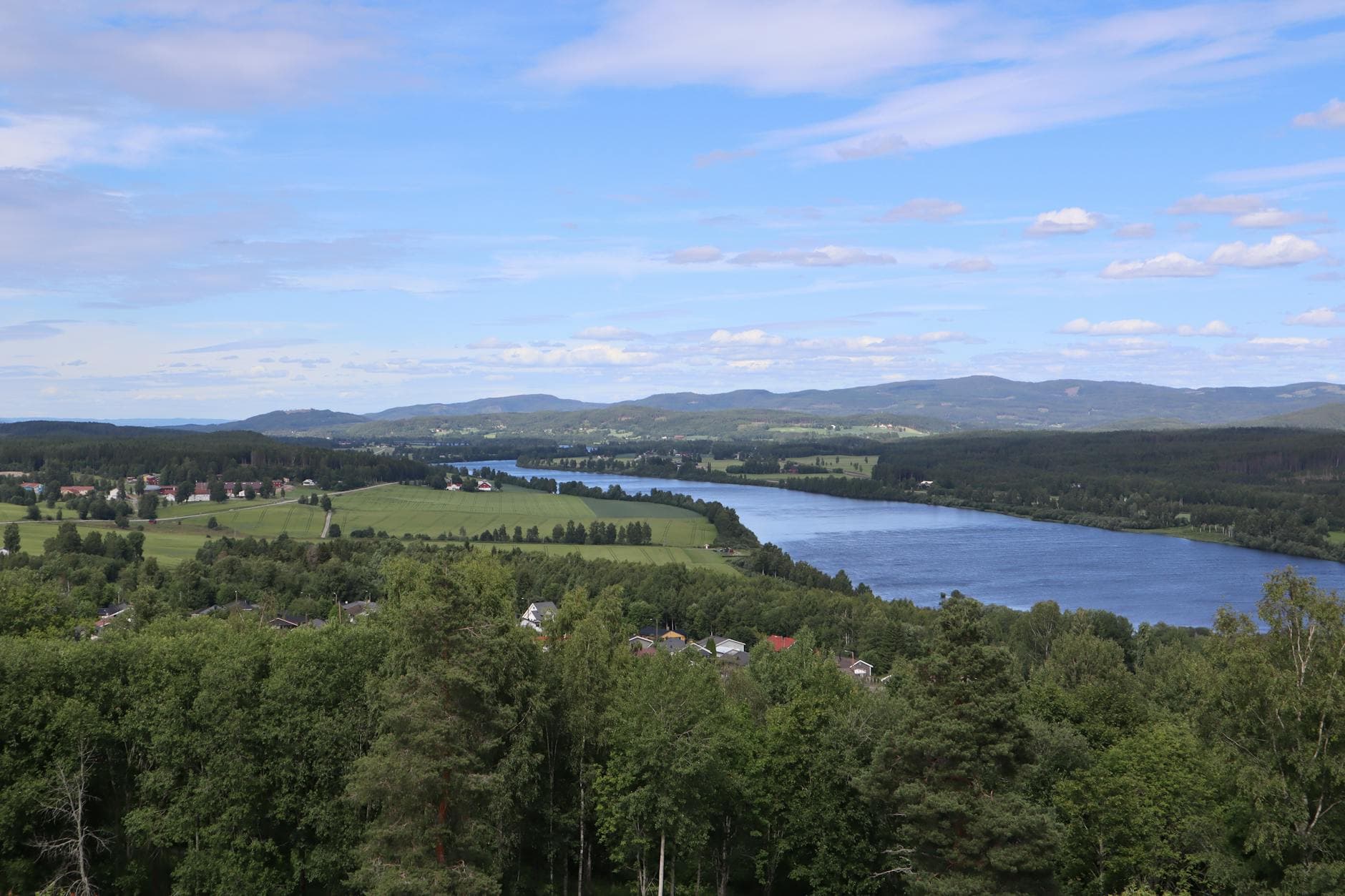 Aerial view of Kongsvinger with lush forests, hills, and the Glomma River in Norway.