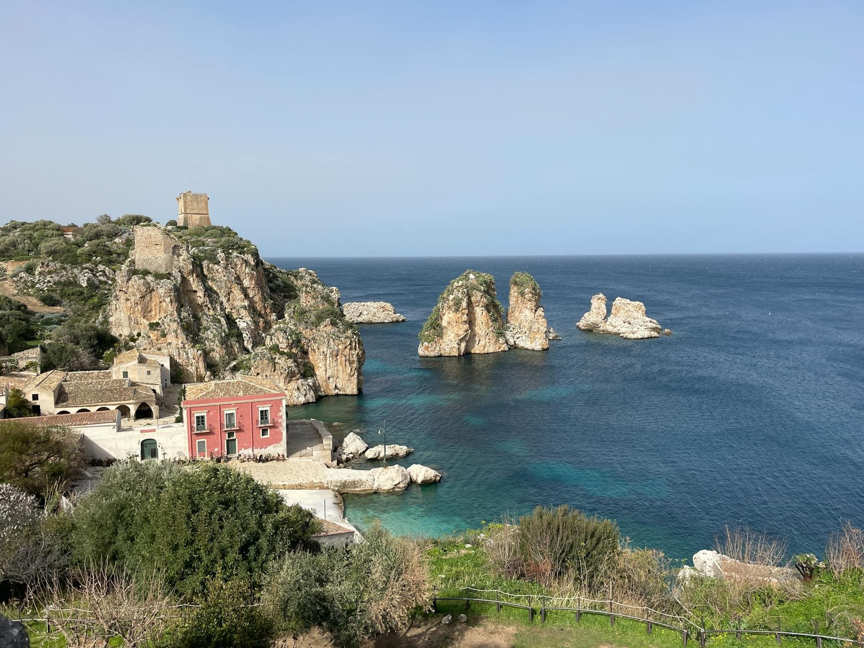 Picturesque view of Scopello's coastline in Sicily, featuring dramatic cliffs and crystal-clear water.