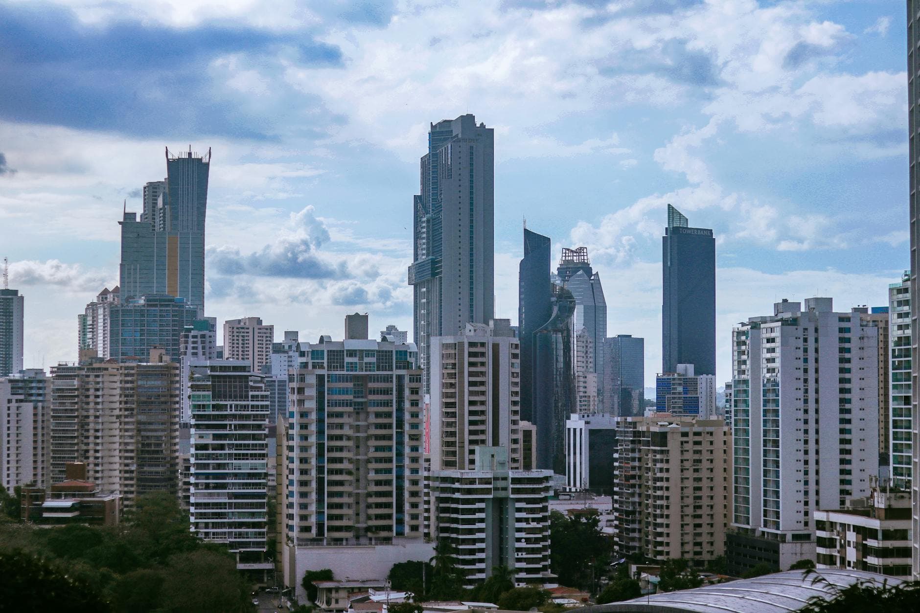 Panama City's modern skyline with towering skyscrapers under a partly cloudy sky.