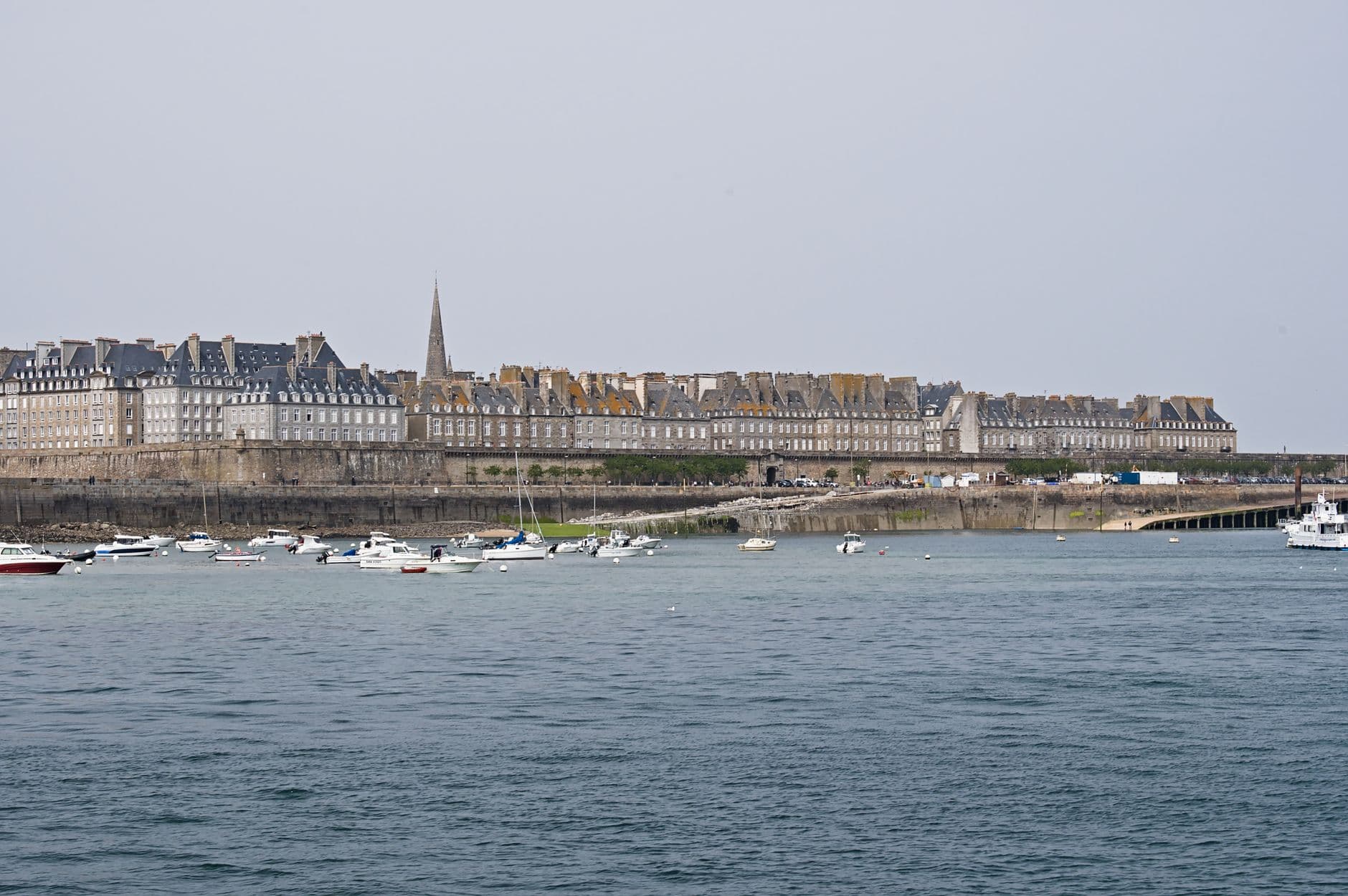 Explore the charming coastal view of Saint-Malo's historic walled city with boats in Brittany, France.