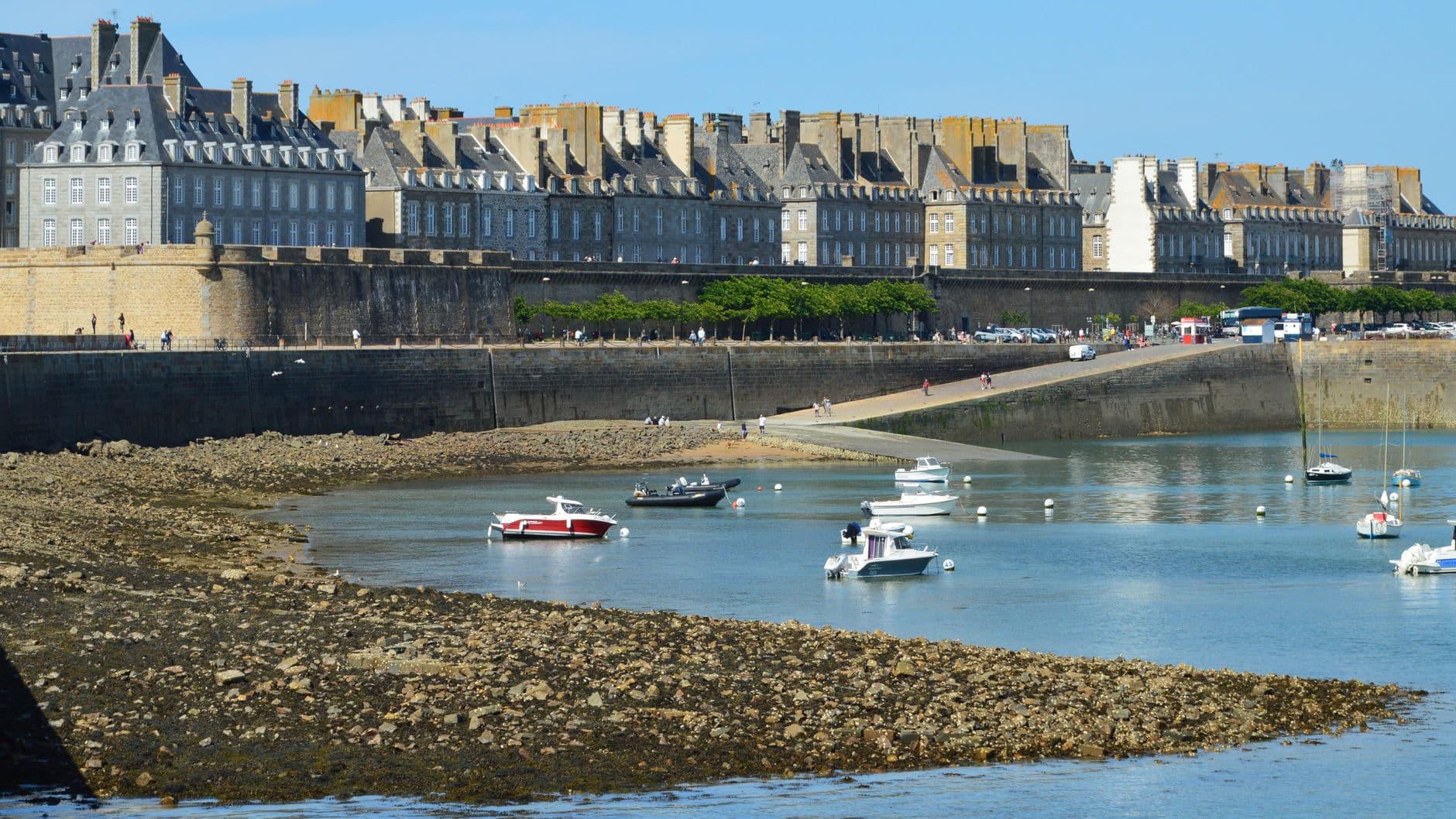 Charming coastal view of Saint-Malo, France, featuring historic fortifications and anchored boats.