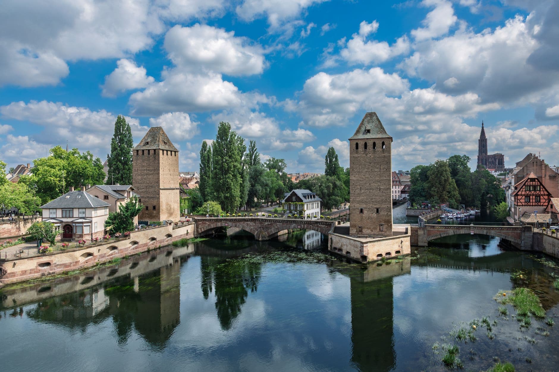 A scenic view of historic towers and bridges over the river in Strasbourg, France.