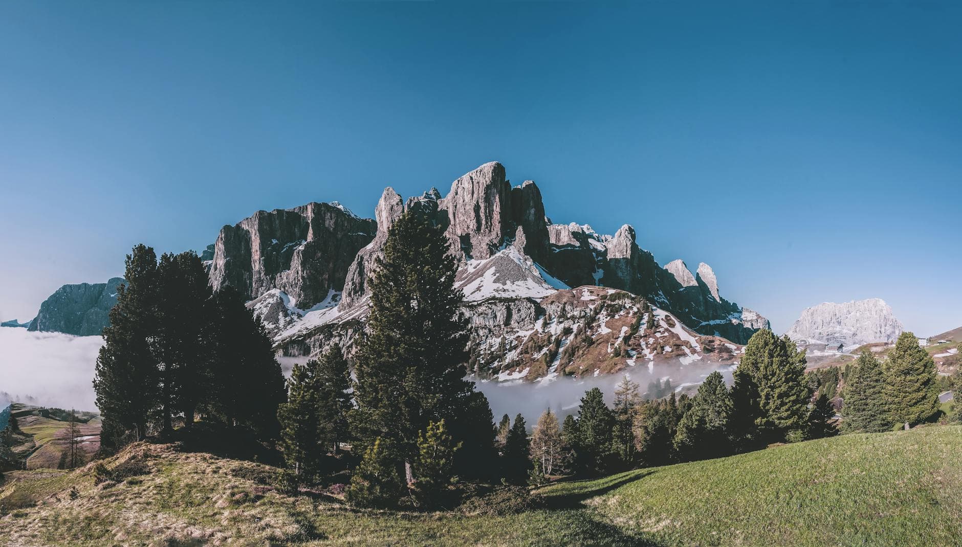 Majestic view of the Dolomites in Selva di Val Gardena, Italy, with clear skies and lush greenery.
