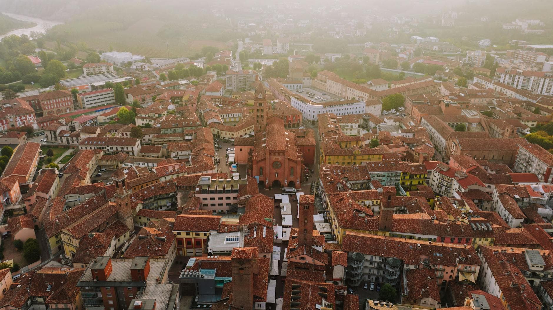 Explore the picturesque rooftops and historic architecture of Alba, Italy from above.