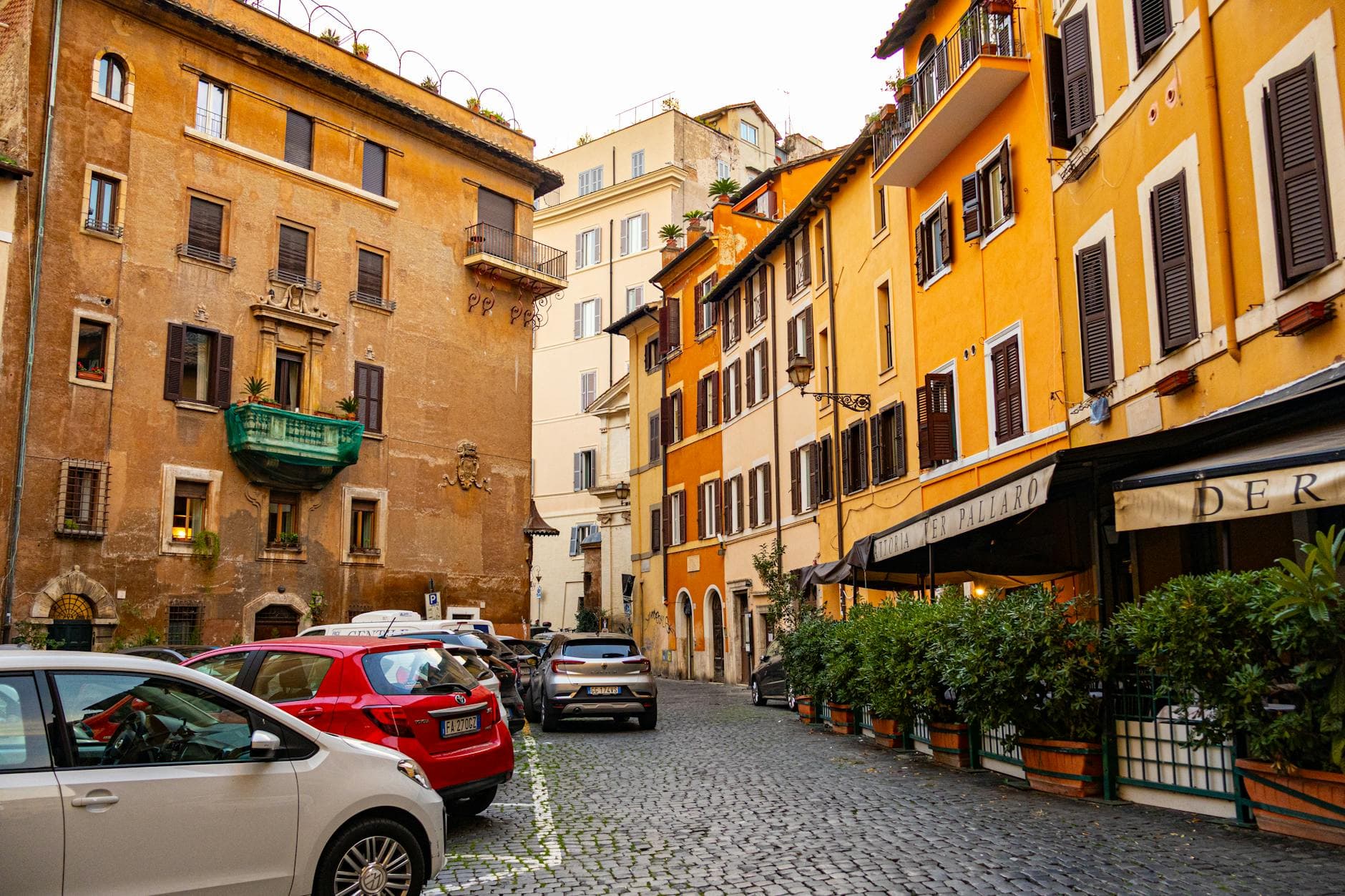 Vibrant historic architecture and parked cars in Largo del Pallaro, Rome, Italy.