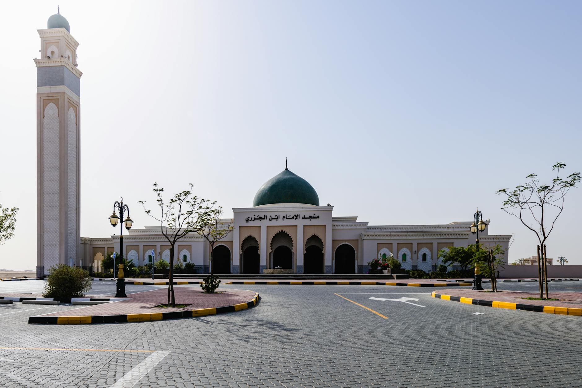 Stunning view of a grand mosque with minaret and dome in Sharjah, UAE under clear sky.