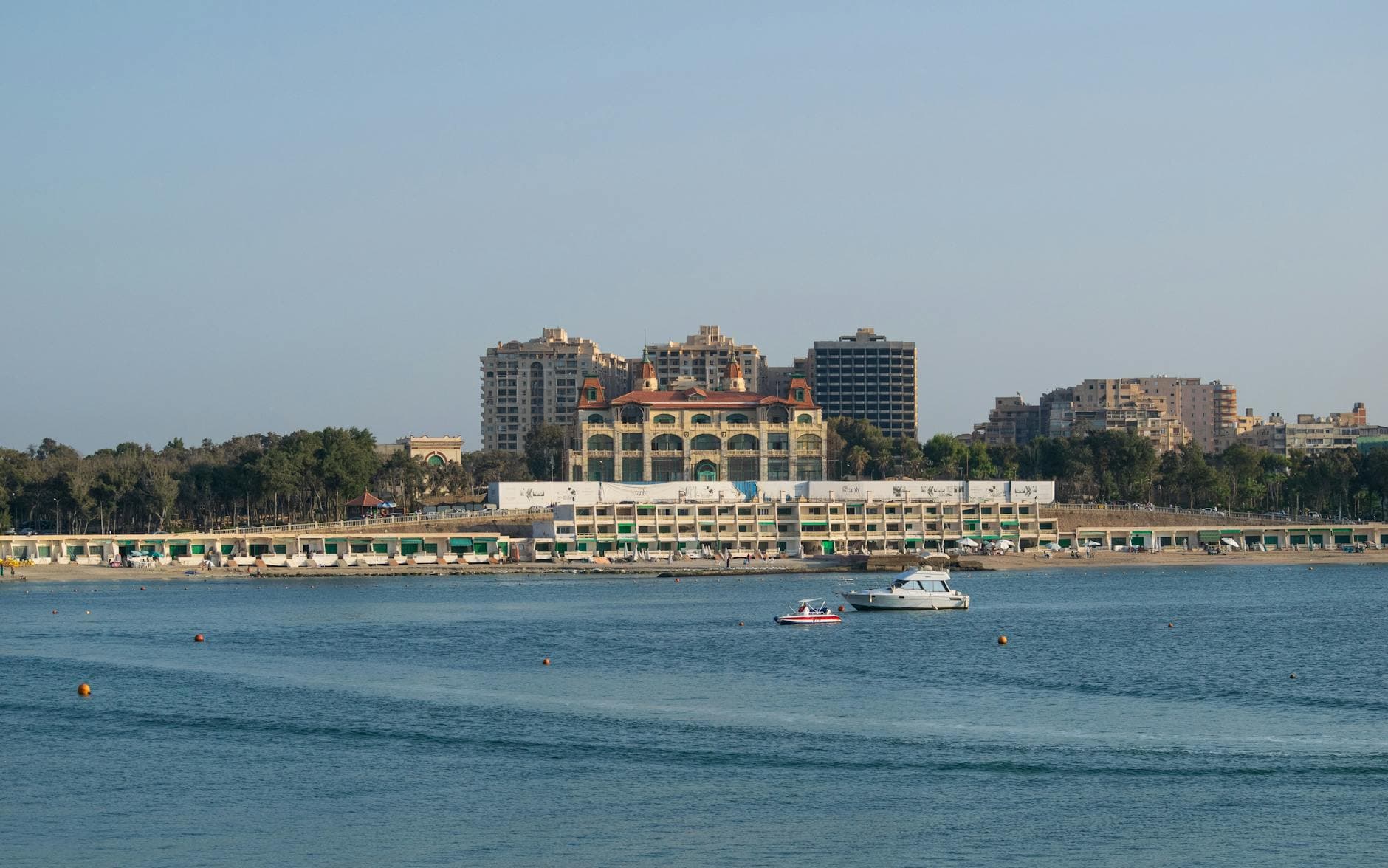 Scenic view of Alexandria's coastline with buildings and watercrafts.
