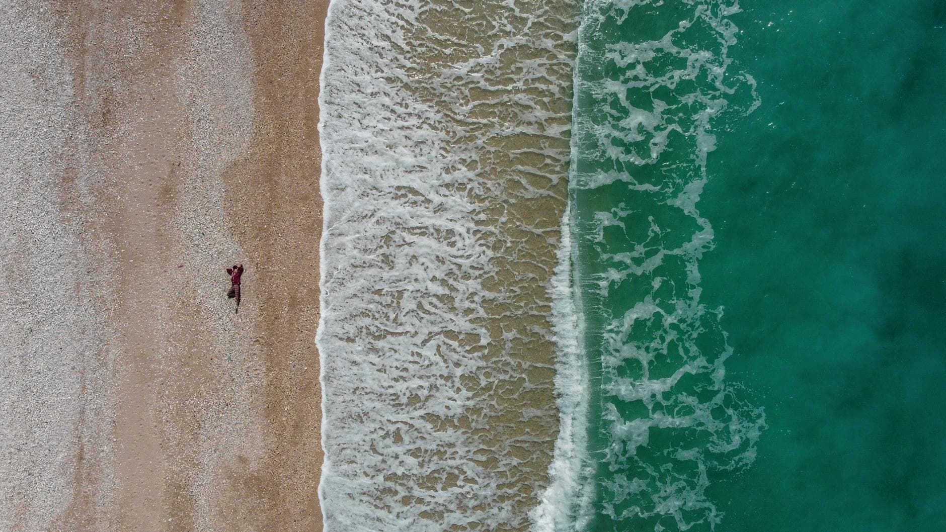 Explore the stunning aerial view of Borsh Beach, Albania with waves crashing on the shore.