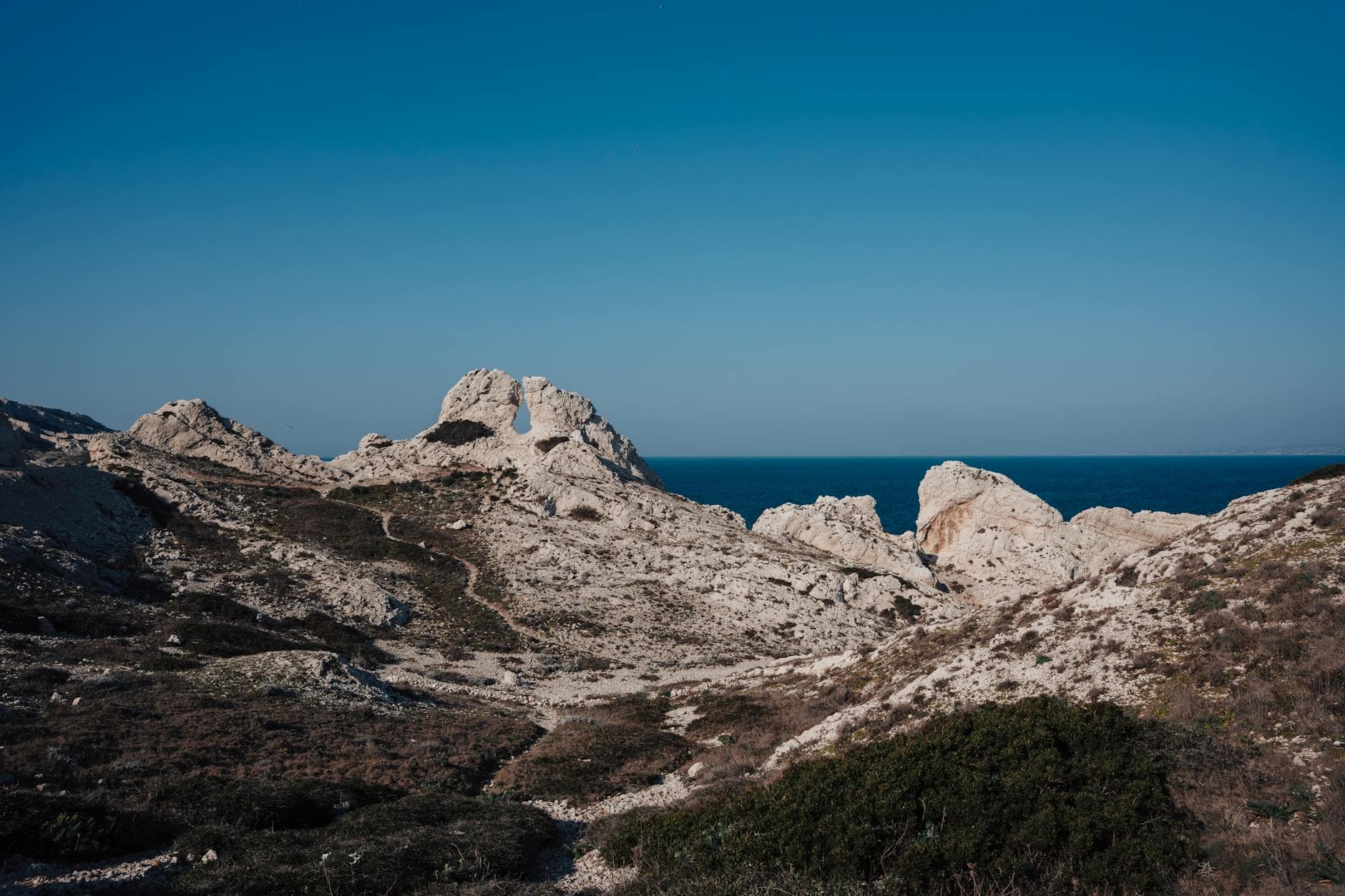 Breathtaking view of rocky coastal landscape under a clear blue sky.