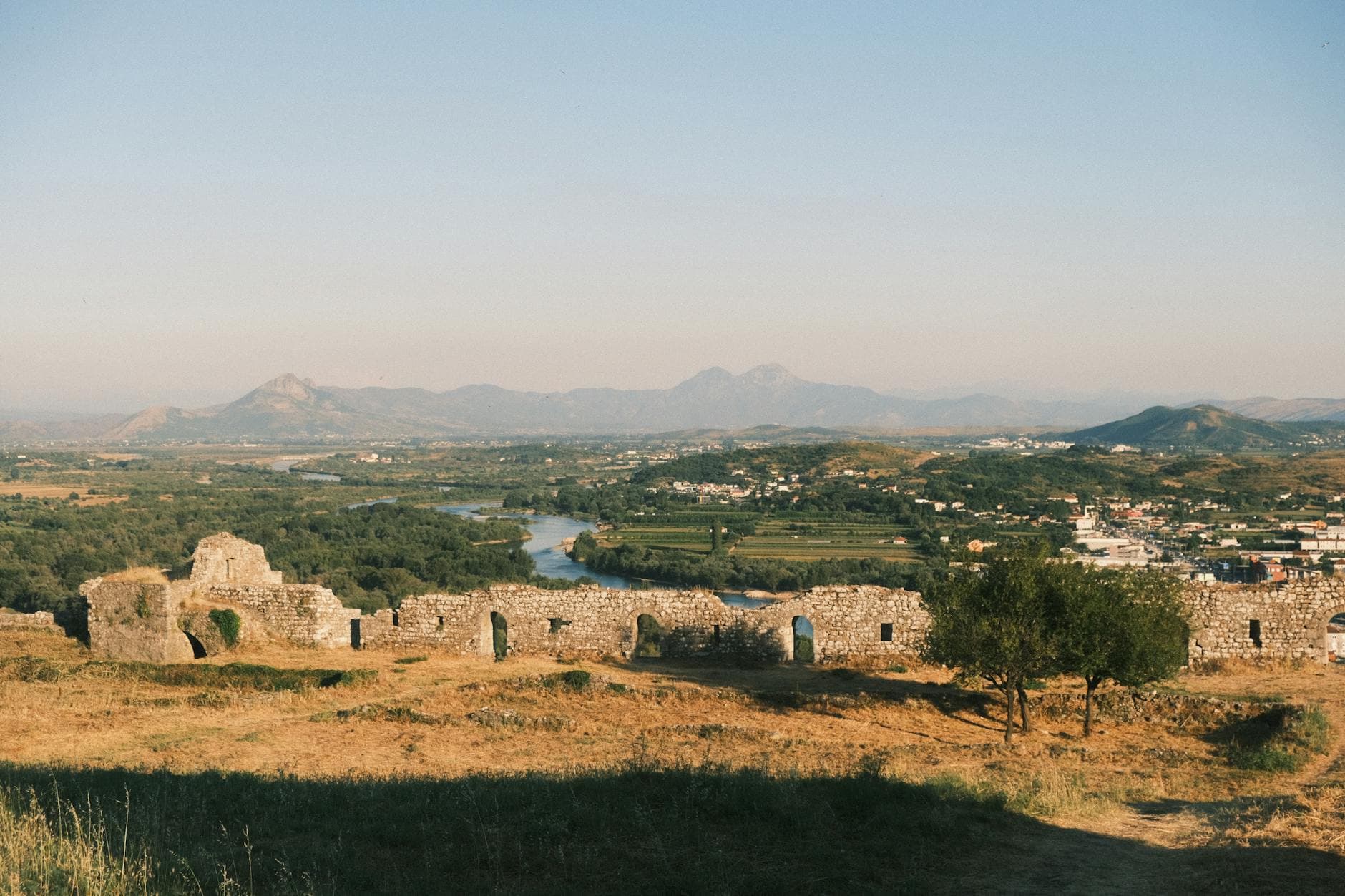 A panoramic view of the Albanian landscape and Shkodër Castle ruins from Rozafa Castle during a summer day.