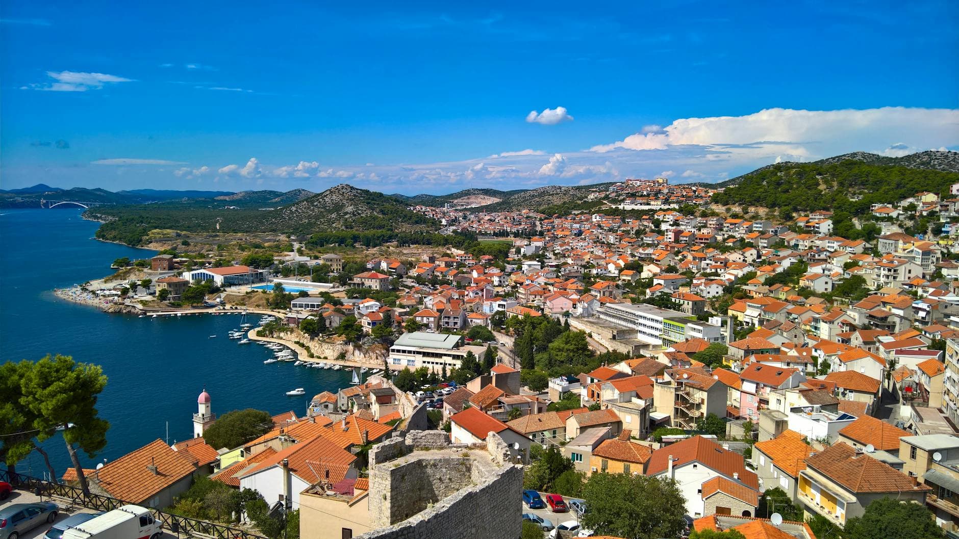 A vibrant view of the coastal town of Sibenik, Croatia, showcasing red roofs and blue Adriatic Sea.