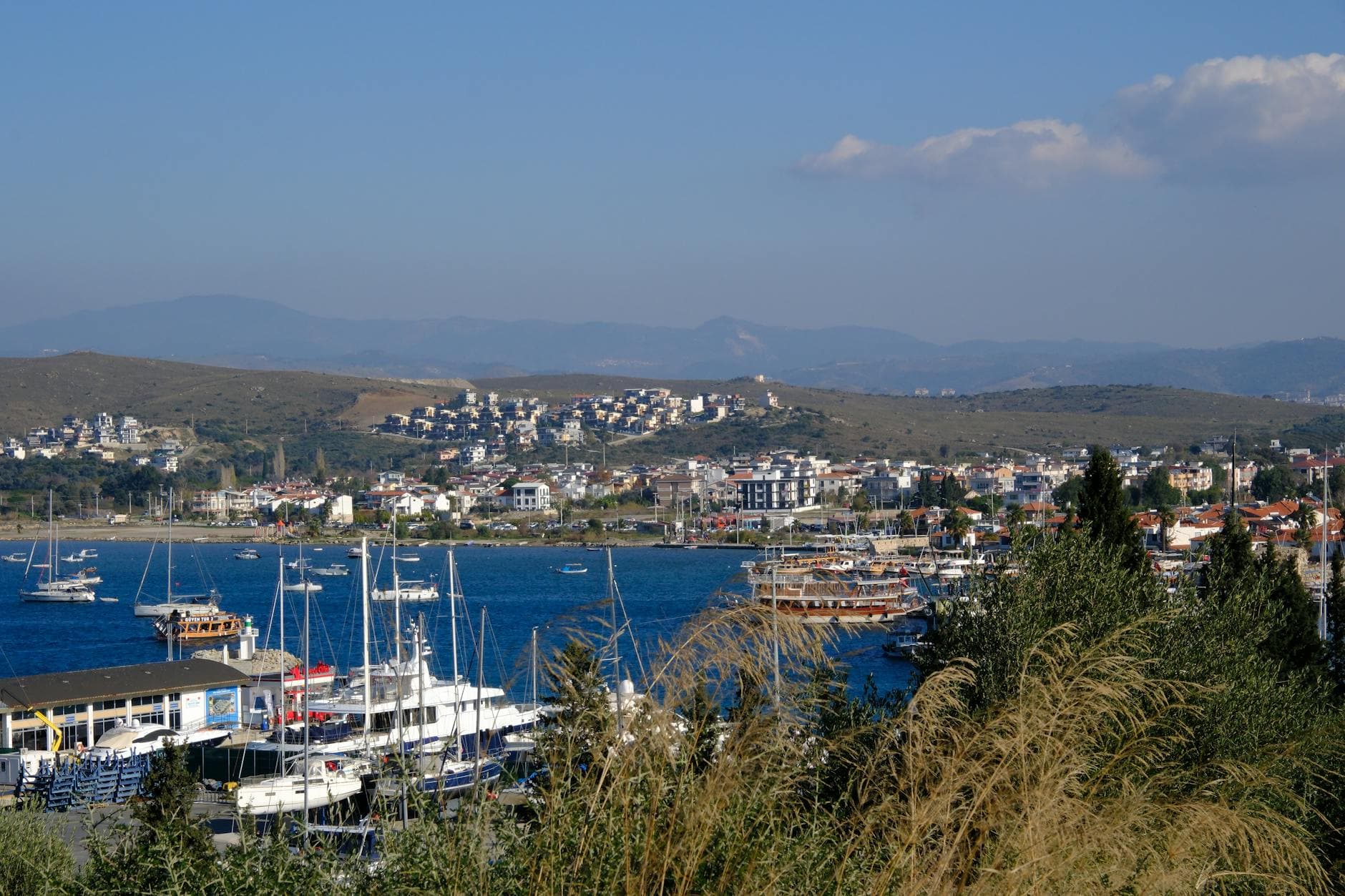 Explore the scenic harbor of Sığacık, İzmir, showcasing yachts and idyllic coastal architecture.