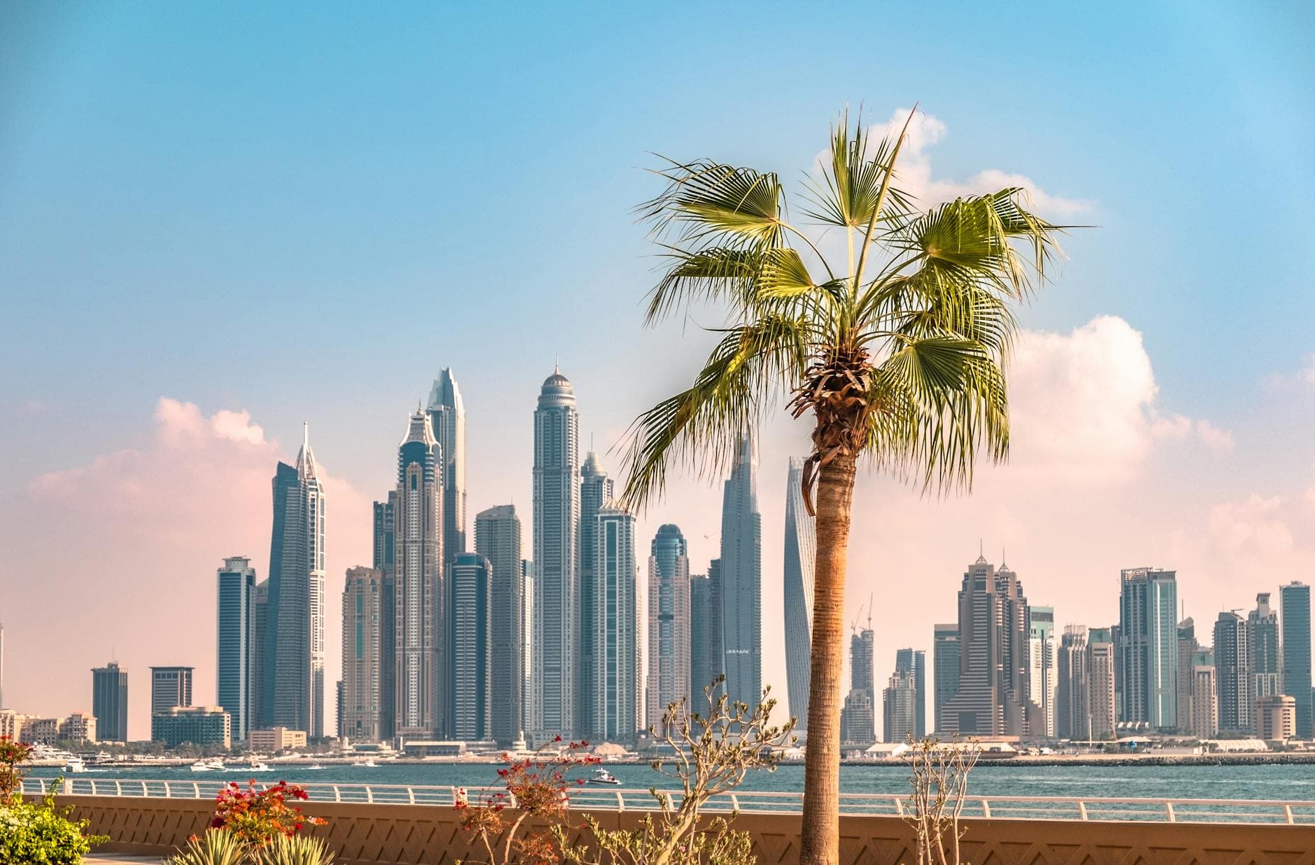 Captivating view of Dubai skyline featuring a prominent palm tree, under a clear blue sky.