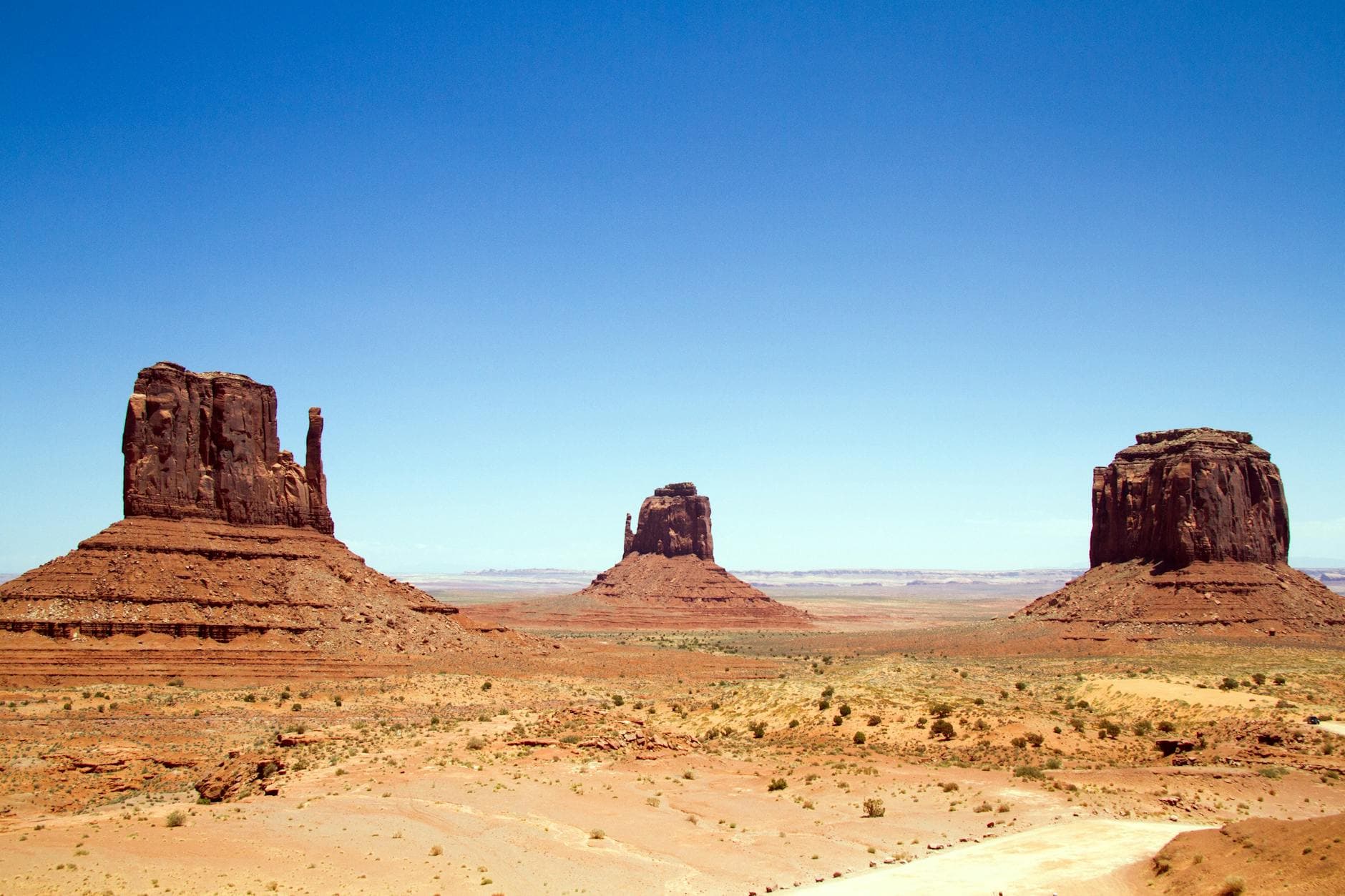 Stunning view of Monument Valley's iconic rock formations under a clear blue sky.