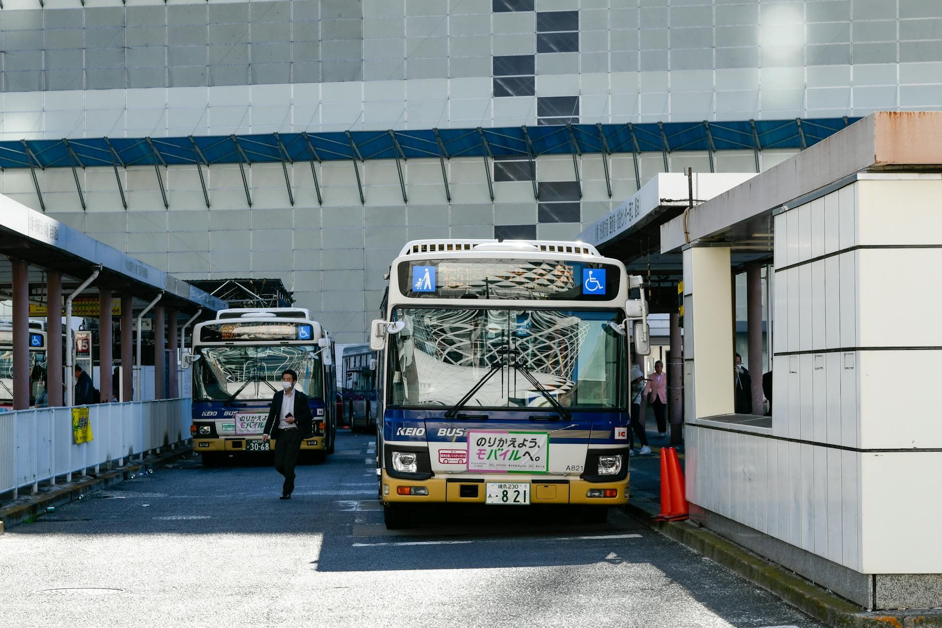Urban scene featuring Keio buses at a bus station in Japan, showcasing public transportation and city life.