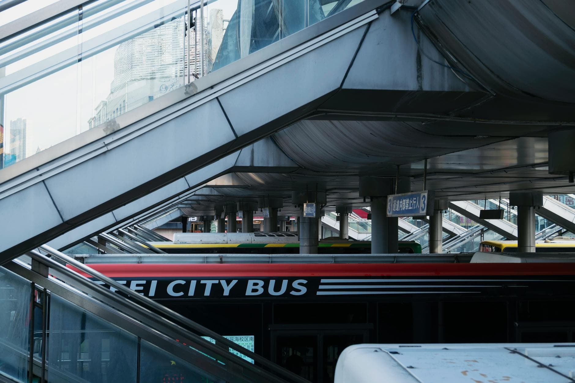 Dynamic view of a city bus station with a modern architectural design and colorful buses.
