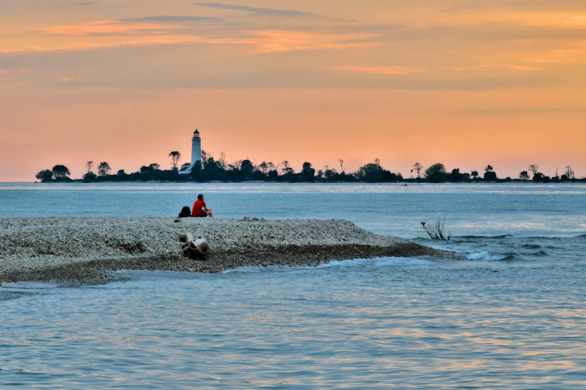 Relaxing by the shoreline with a lighthouse view at sunset in Southampton, Canada.