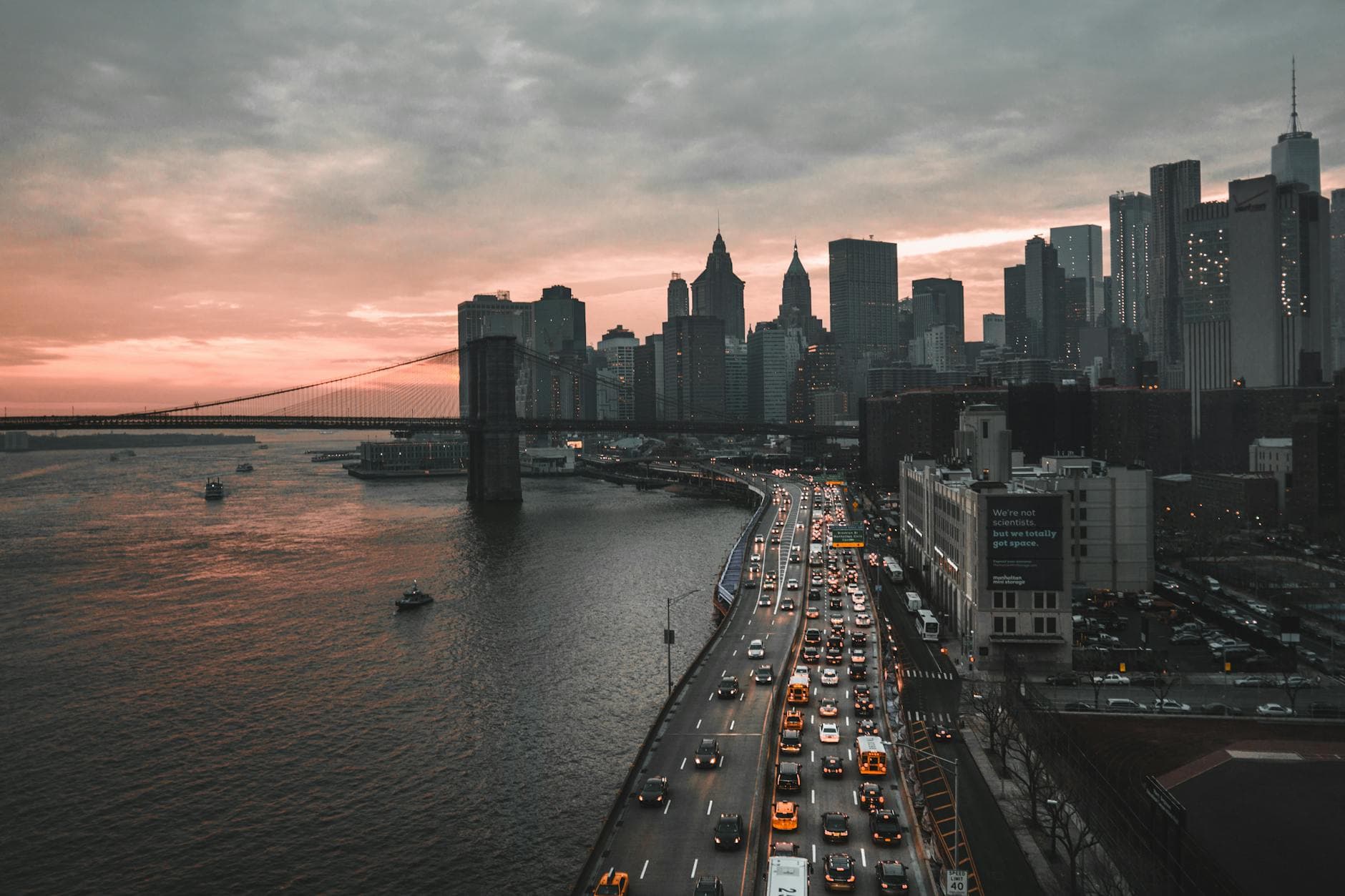 A stunning view of New York City's skyline at dusk featuring the iconic Brooklyn Bridge and bustling waterfront.