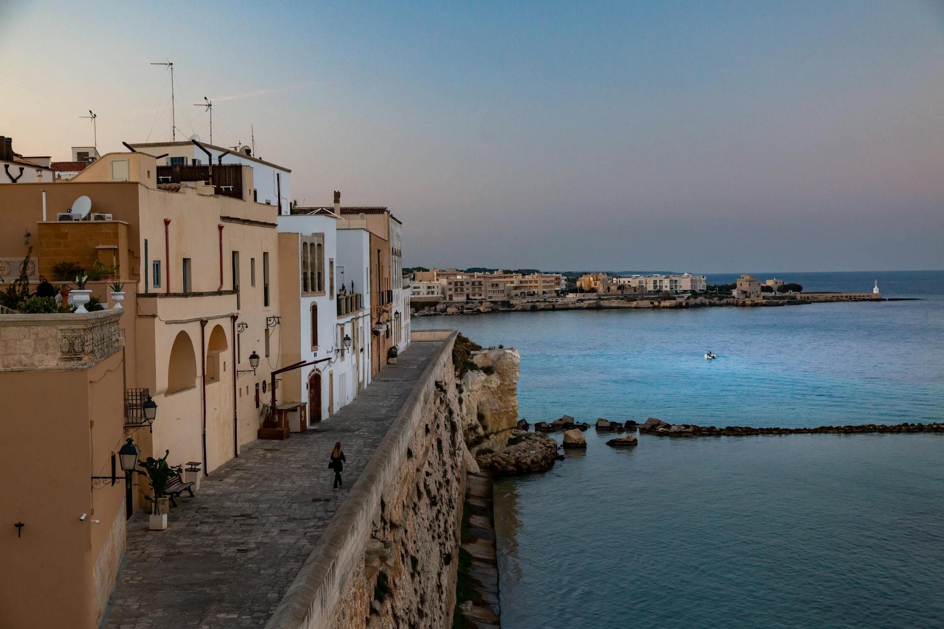 A scenic coastal town with historic architecture and calm sea view at sunset.