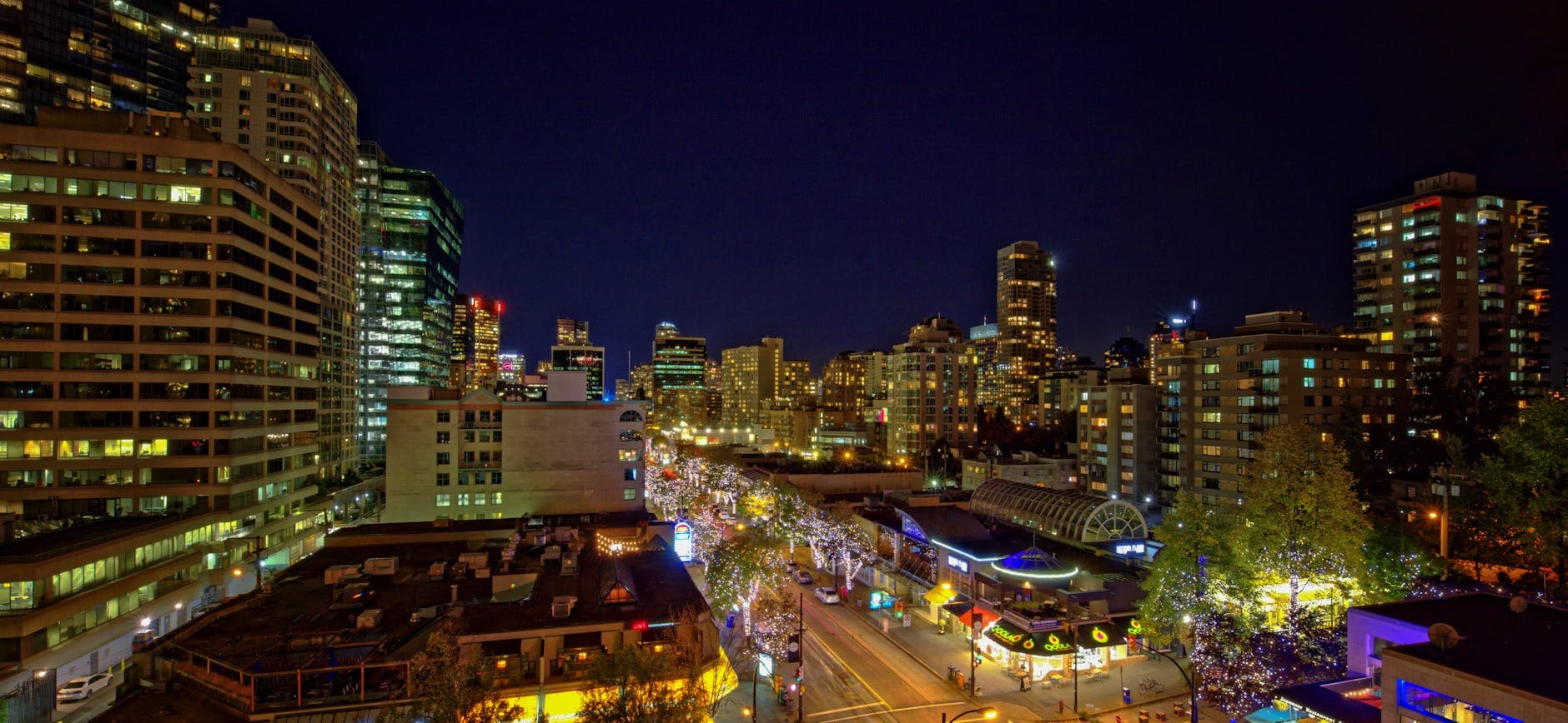 A bustling city skyline at night with brightly lit streets and towering buildings.