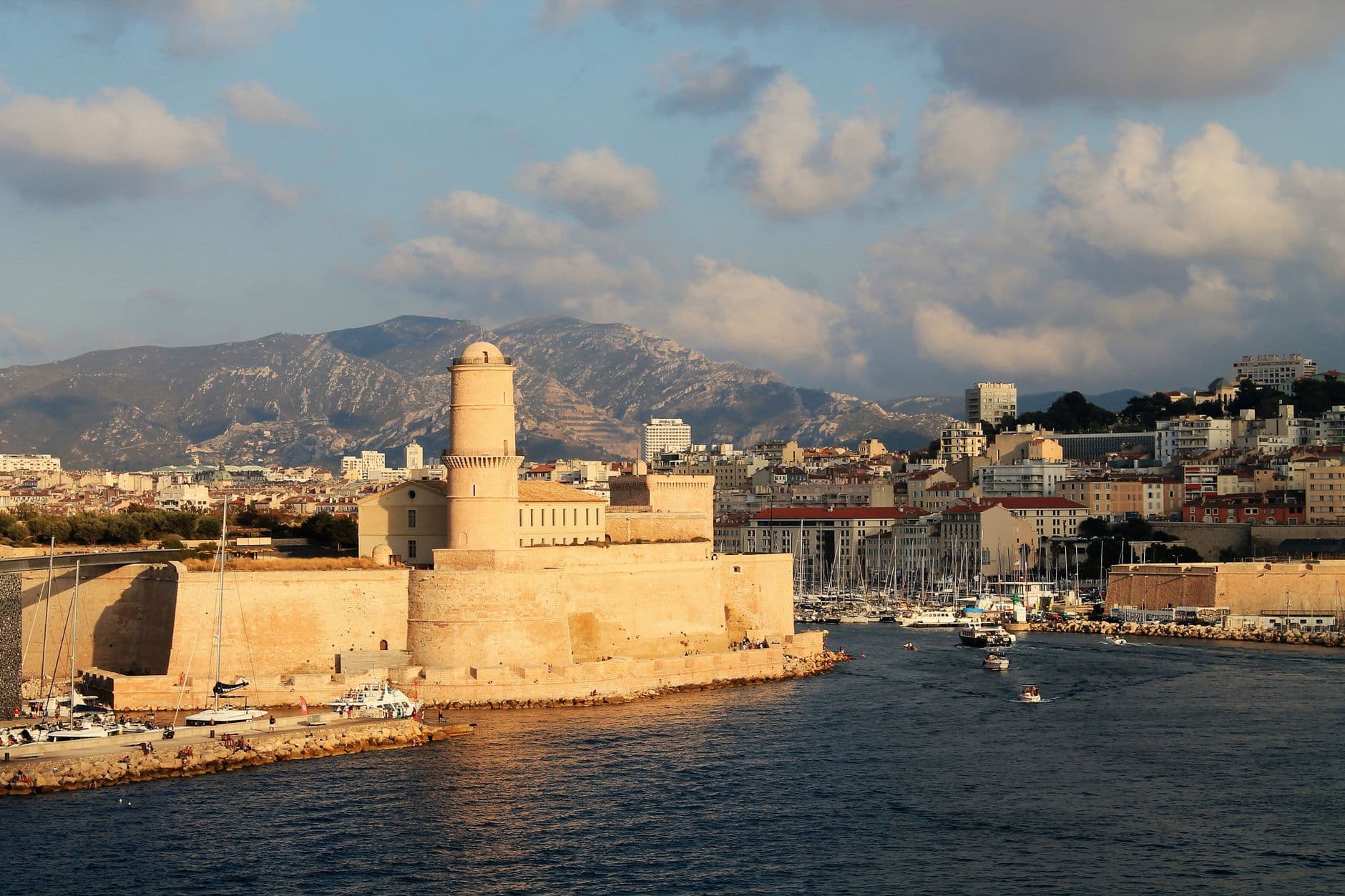 Captivating view of the historic fort and marina in Marseille, France under bright sunlight.