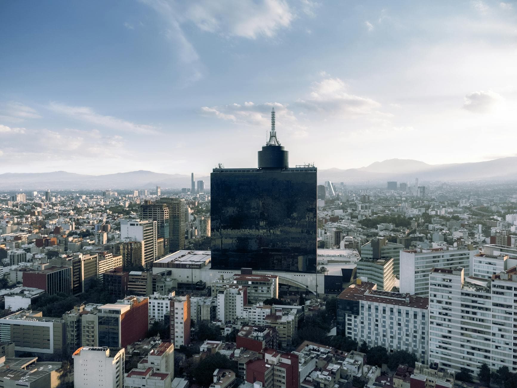 Explore the panoramic skyline of Mexico City featuring a prominent tower against a clear sky.