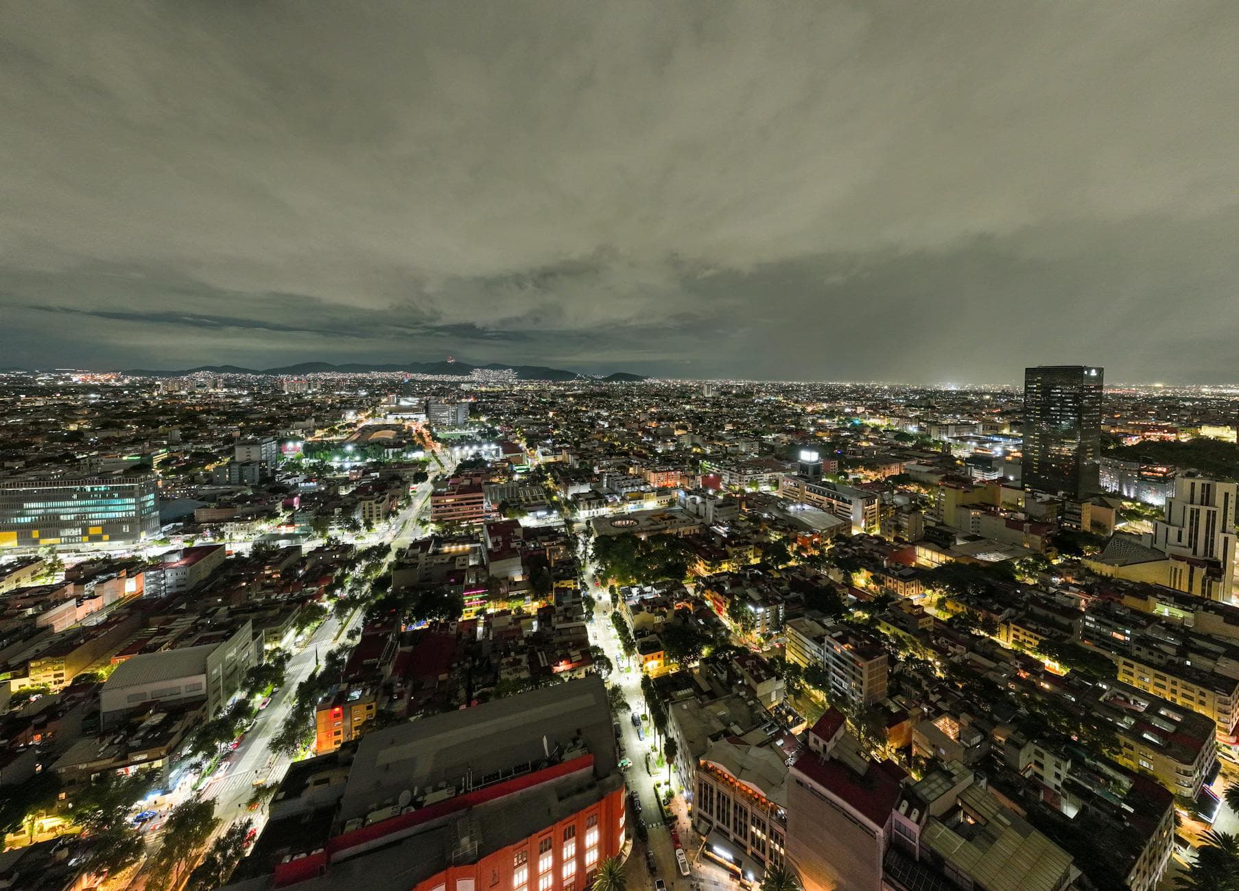 Stunning aerial view of a bustling city lit up at night, showcasing vibrant streets and city lights.