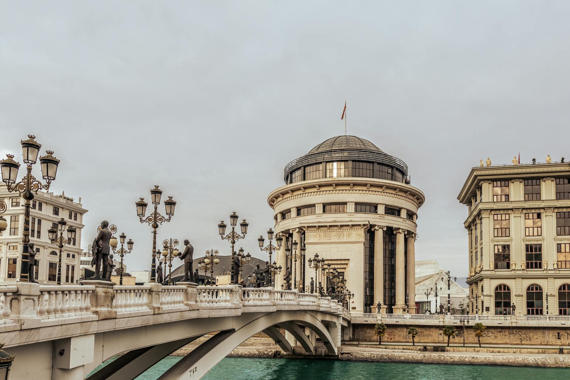 Historic bridge and architecture in Skopje, showcasing cultural landmarks and river views.