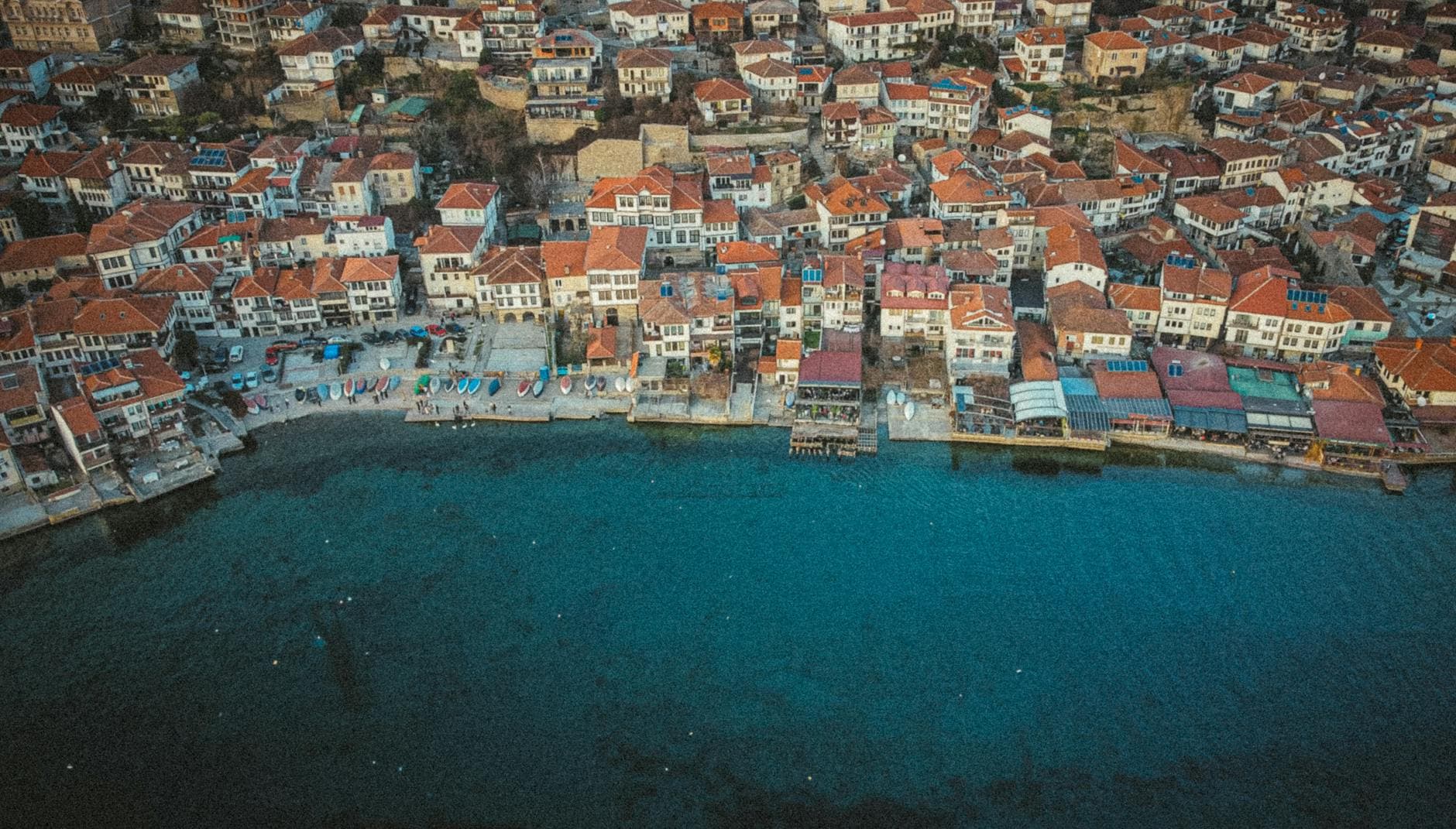 Explore the stunning aerial view of Ohrid's vibrant waterfront with charming red-tiled rooftops.