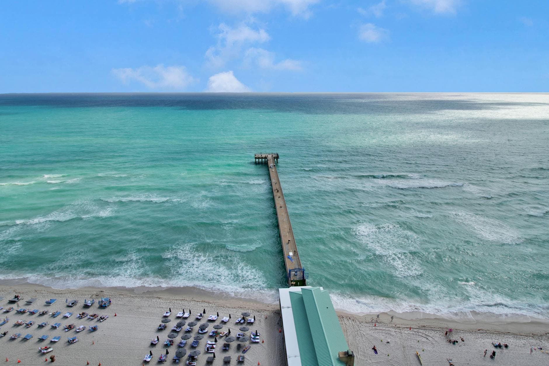 Stunning aerial view of the pier extending into turquoise waters at Sunny Isles Beach, Florida.