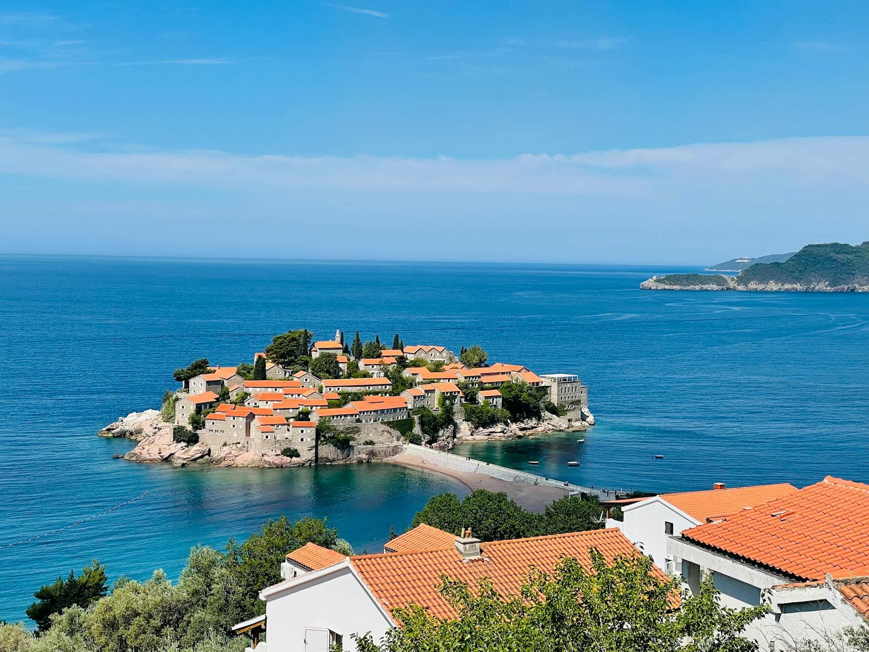 Scenic view of Sveti Stefan island in Montenegro, featuring azure sea and historic architecture.